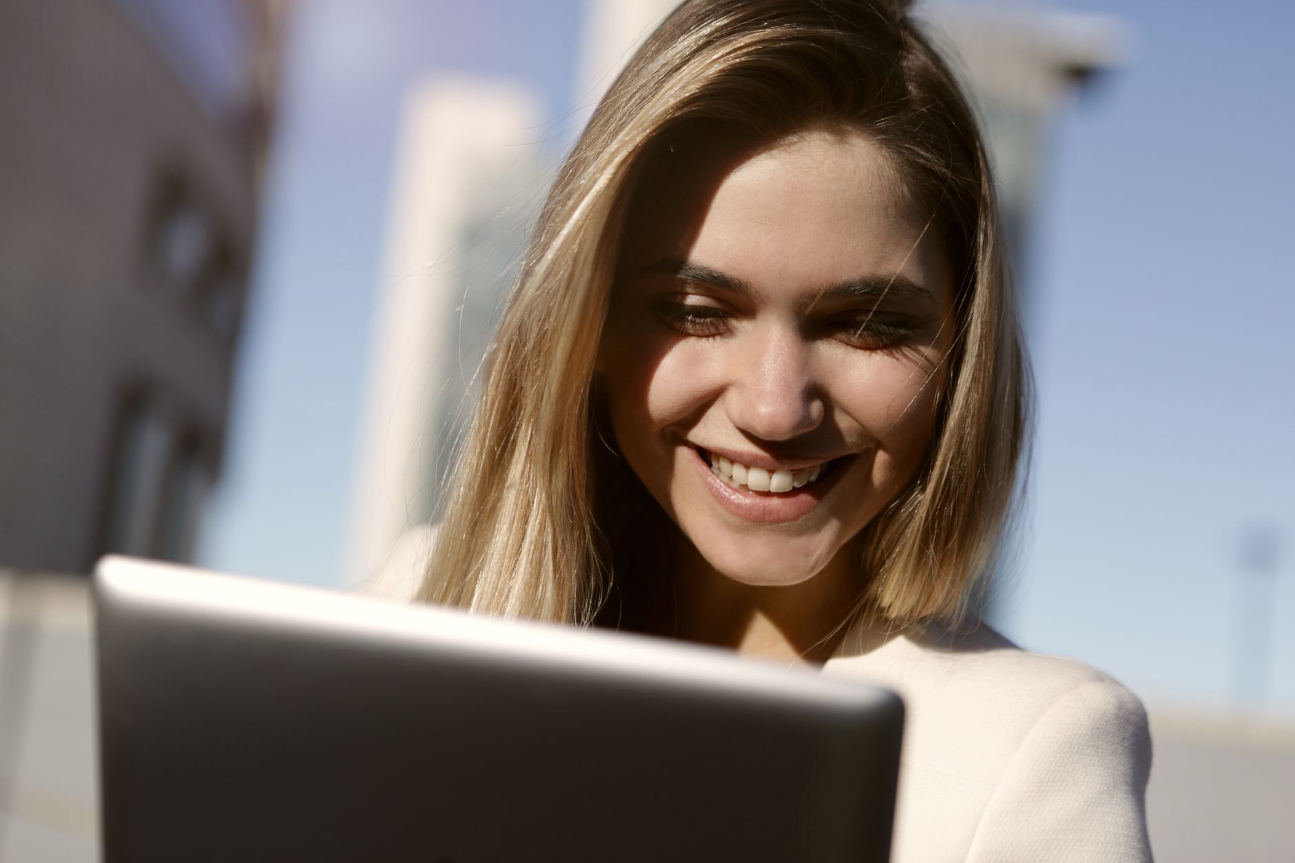 Agente imobiliário revisando fotos de propriedade em um laptop moderno
