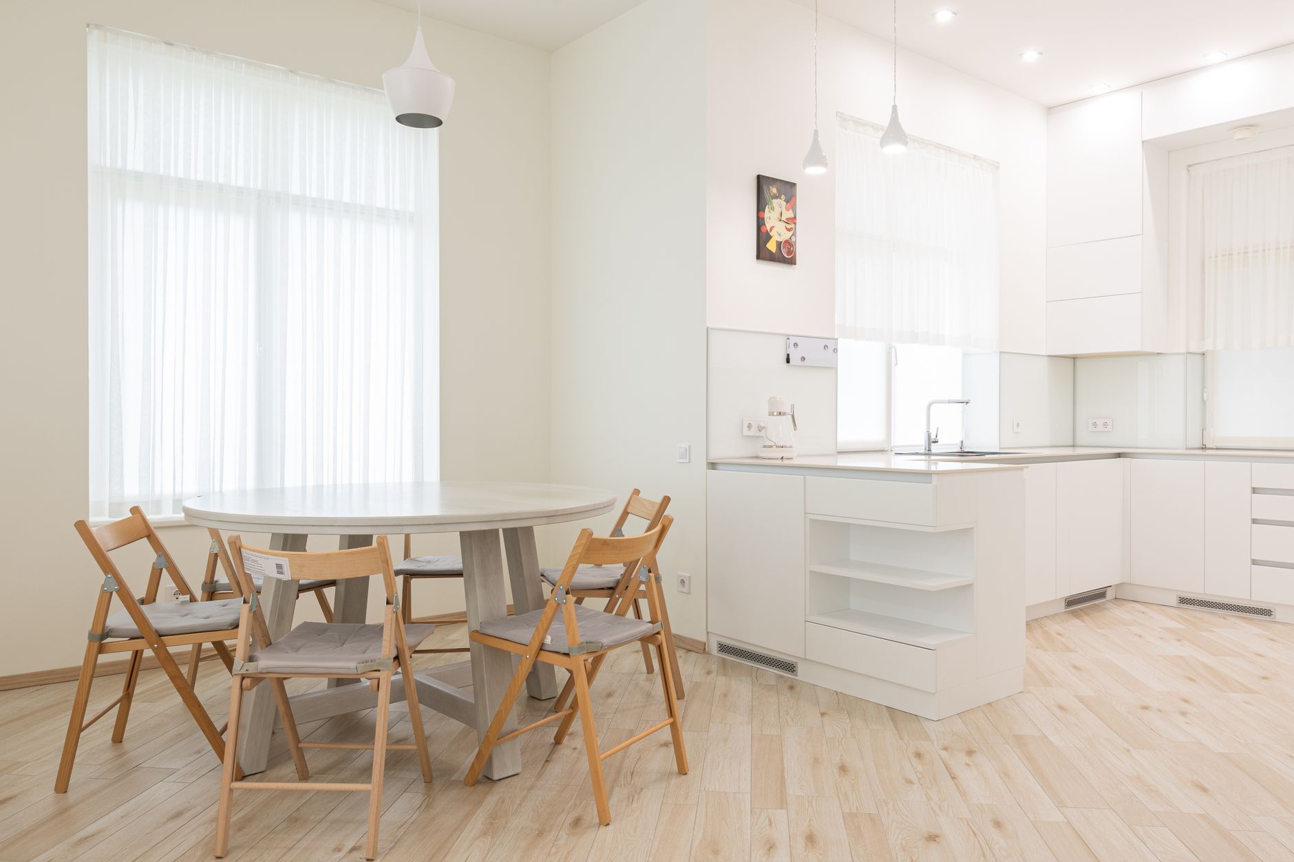 Cozy chairs near round shaped table in contemporary interior of spacious dining room