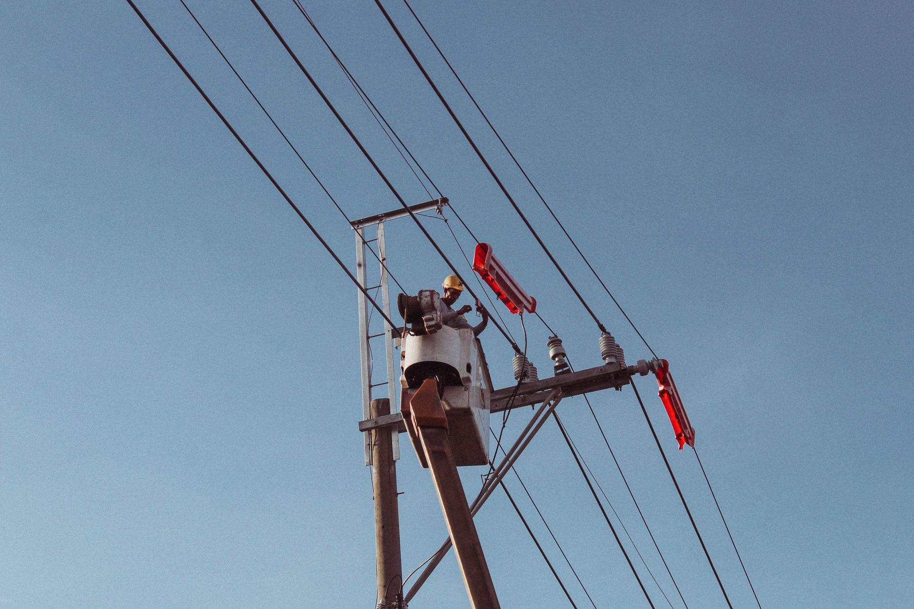 Engineer works on high power lines, ensuring electrical safety and maintenance.
