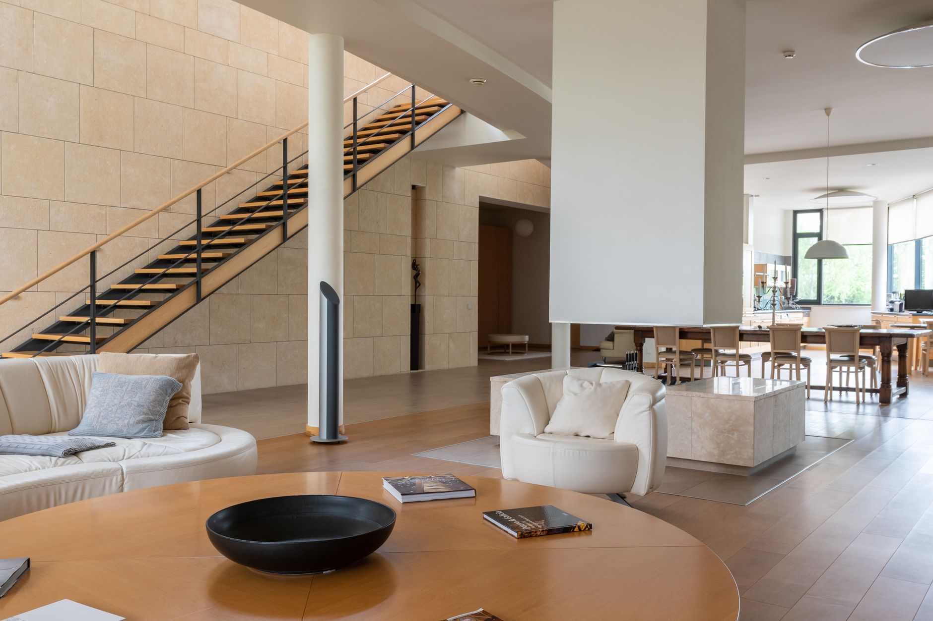 Interior of contemporary large house with double floors and fireplace in middle of living room with light furniture