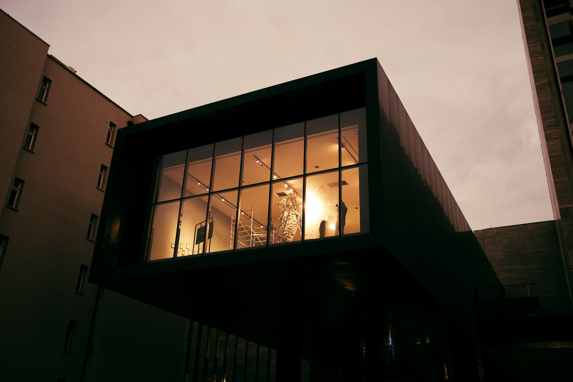 A modern building with illuminated windows during dusk, showcasing elegant architecture.