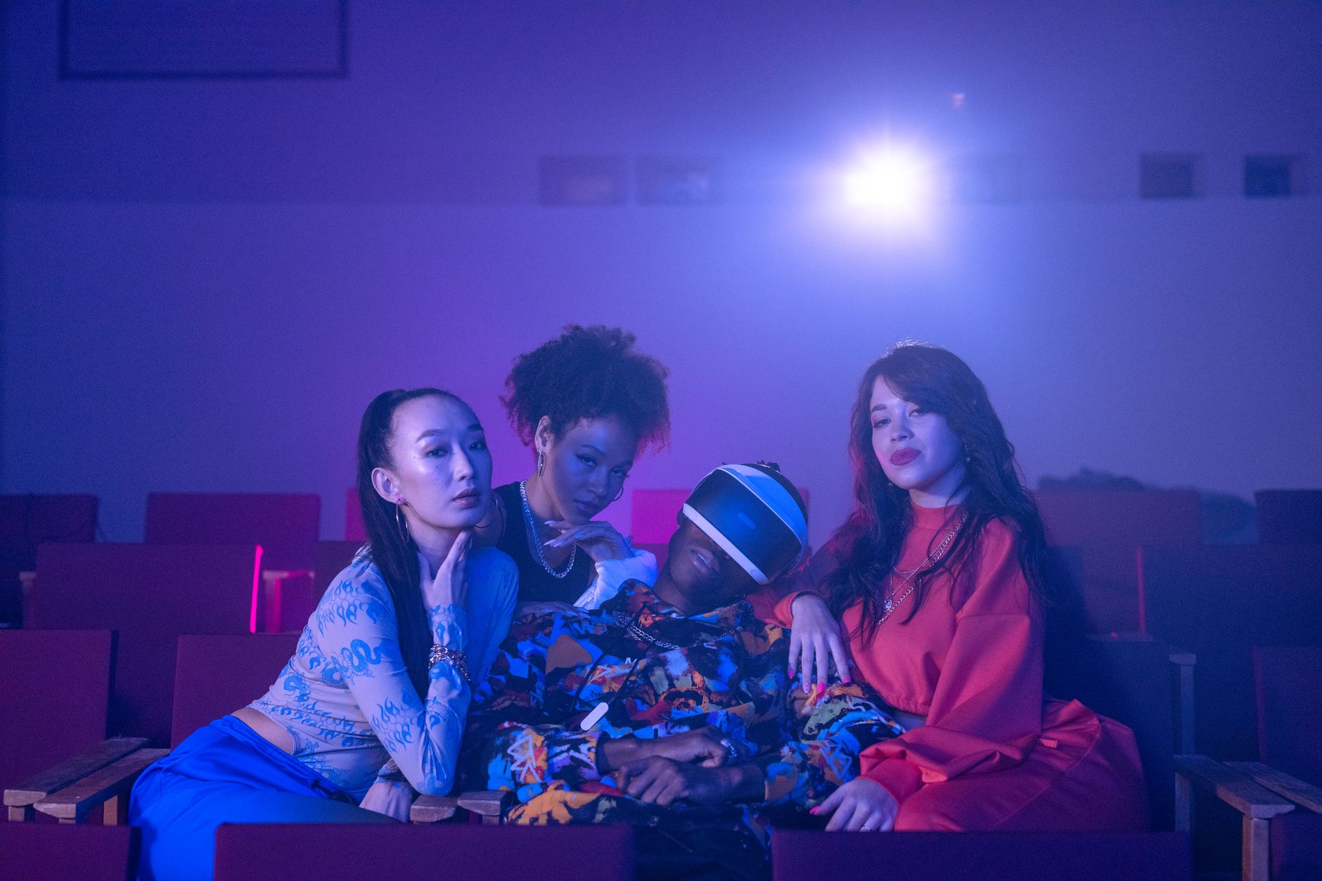 Group seated in a theater setting with a VR headset, dramatic lighting.