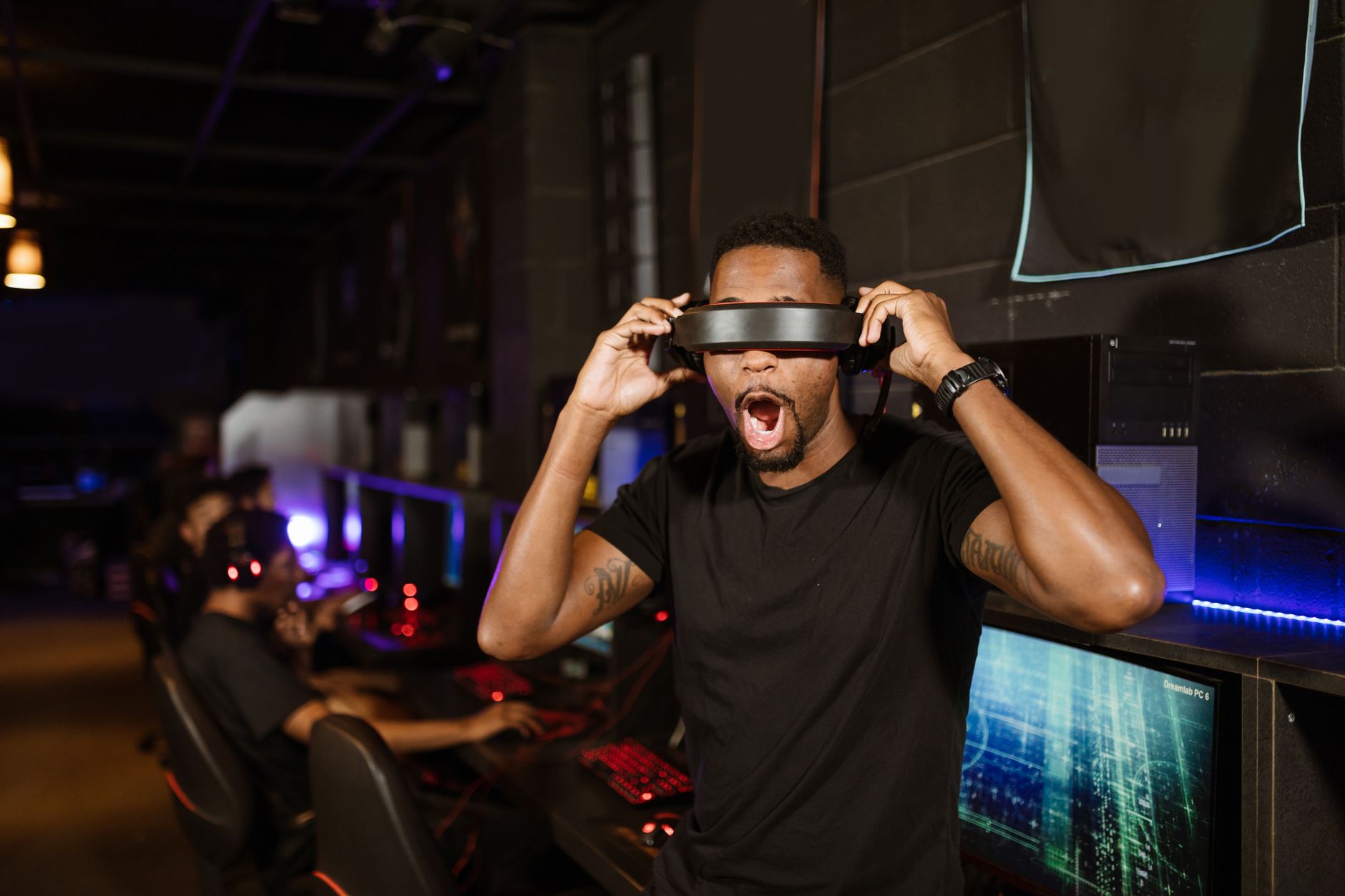 A happy man experiencing virtual reality in a modern gaming lounge.