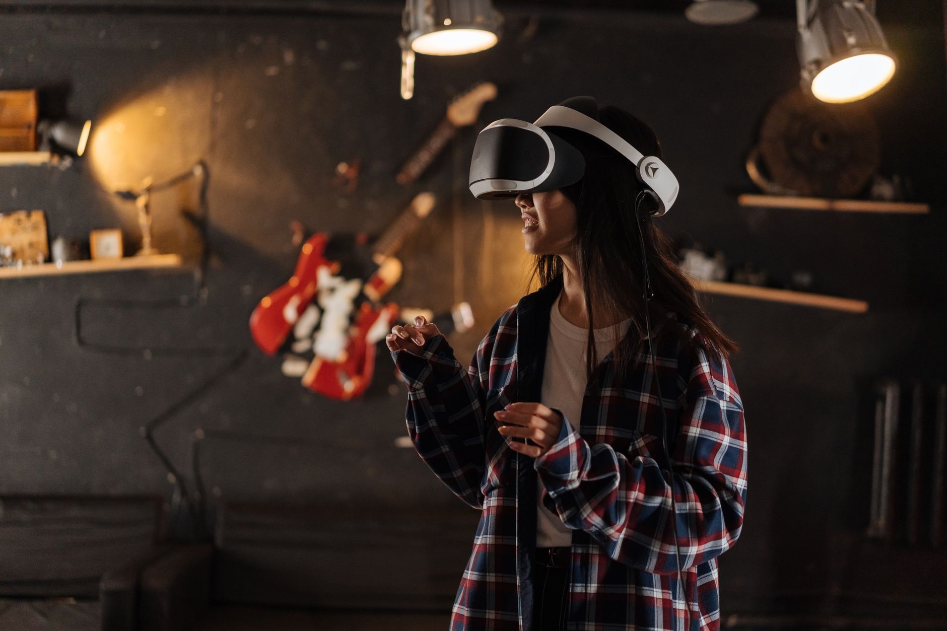 A woman wearing a VR headset playing games indoors, immersed in virtual reality.