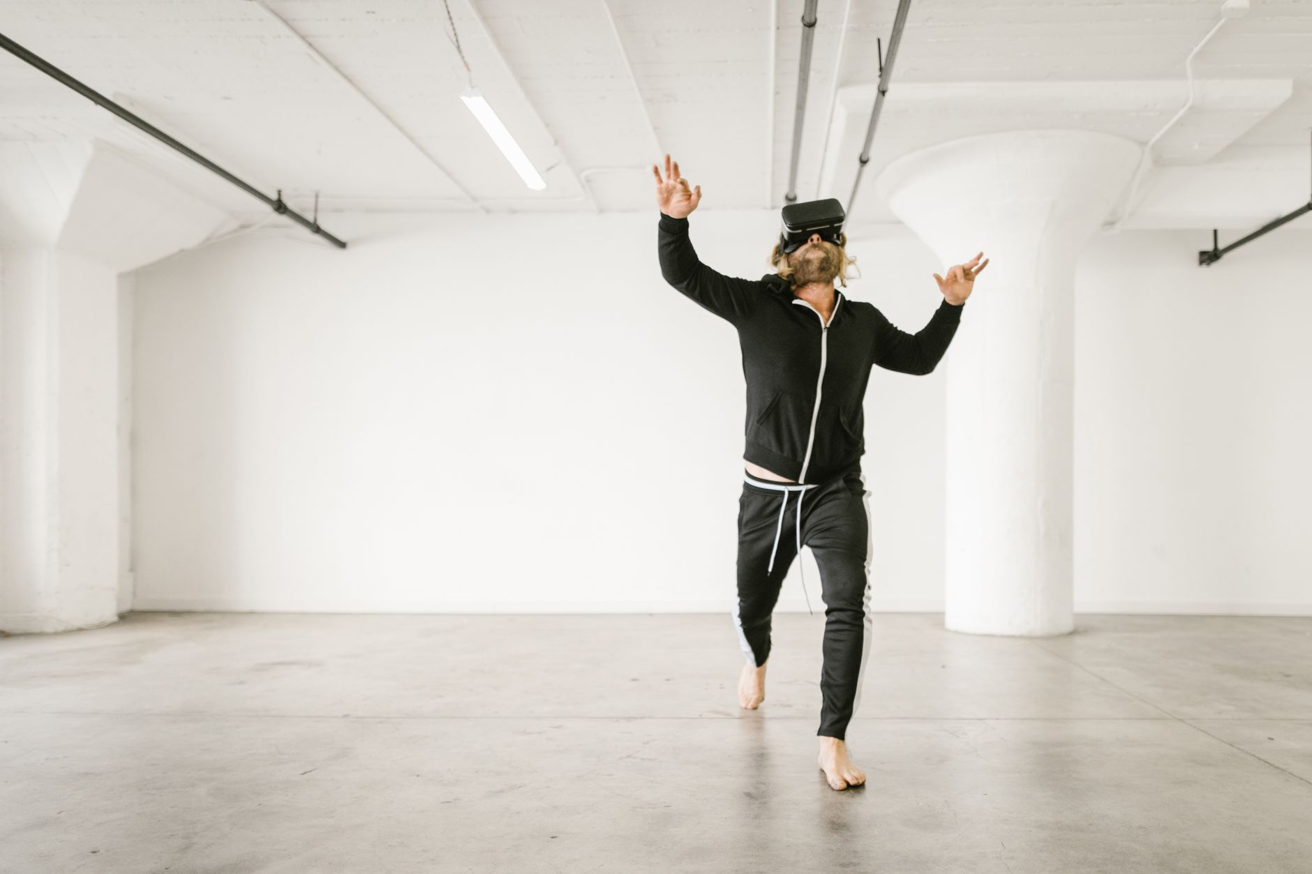 Adult man exploring augmented reality in a minimalist indoor space using a VR headset.