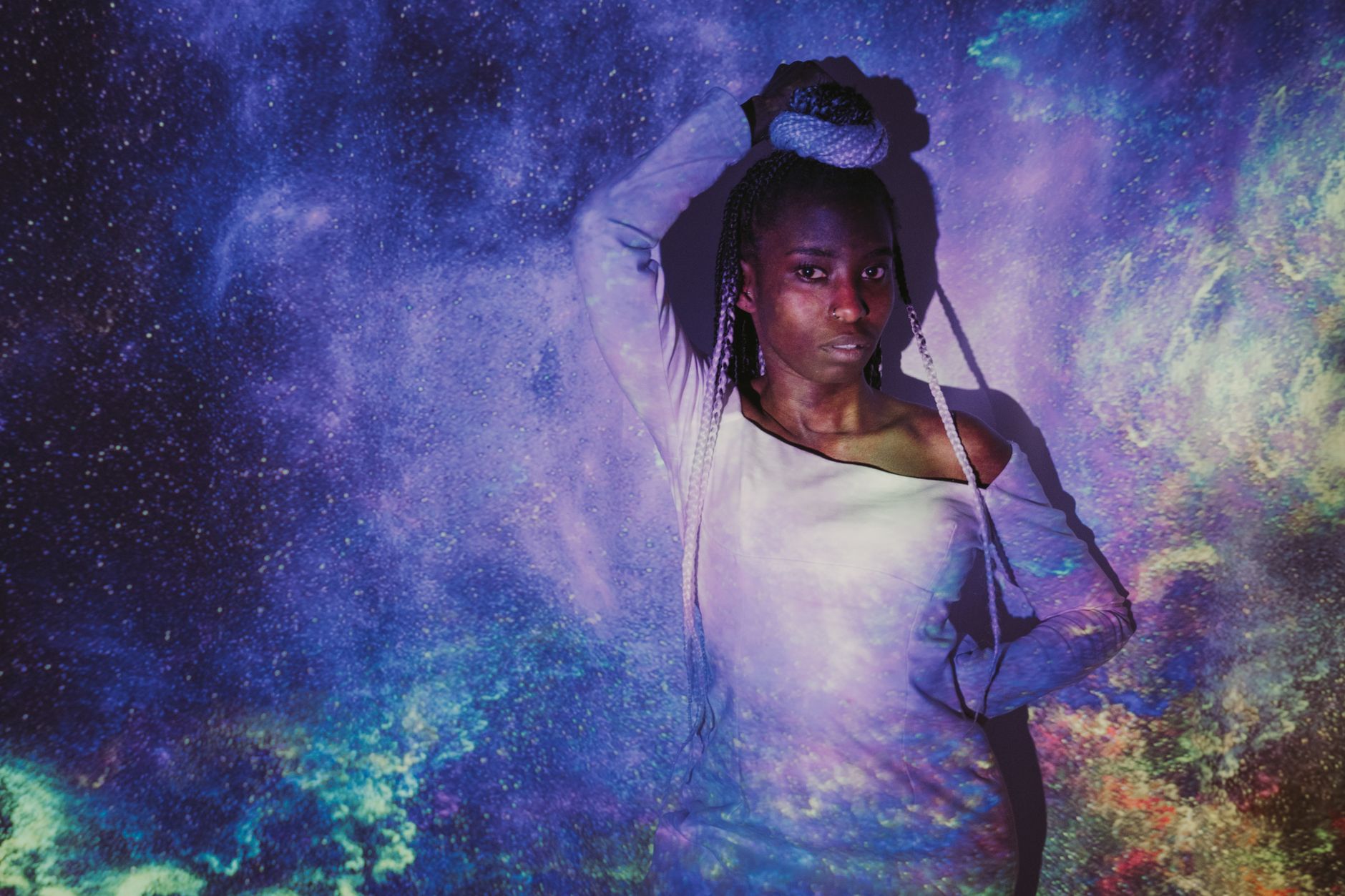 Creative portrait of woman with galaxy projection, blending art and cosmos.