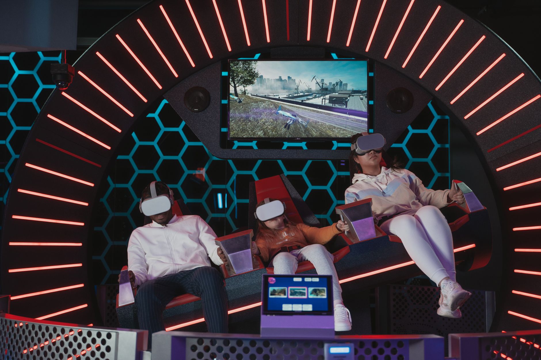 Family immersed in a virtual reality gaming experience at an indoor simulation center.