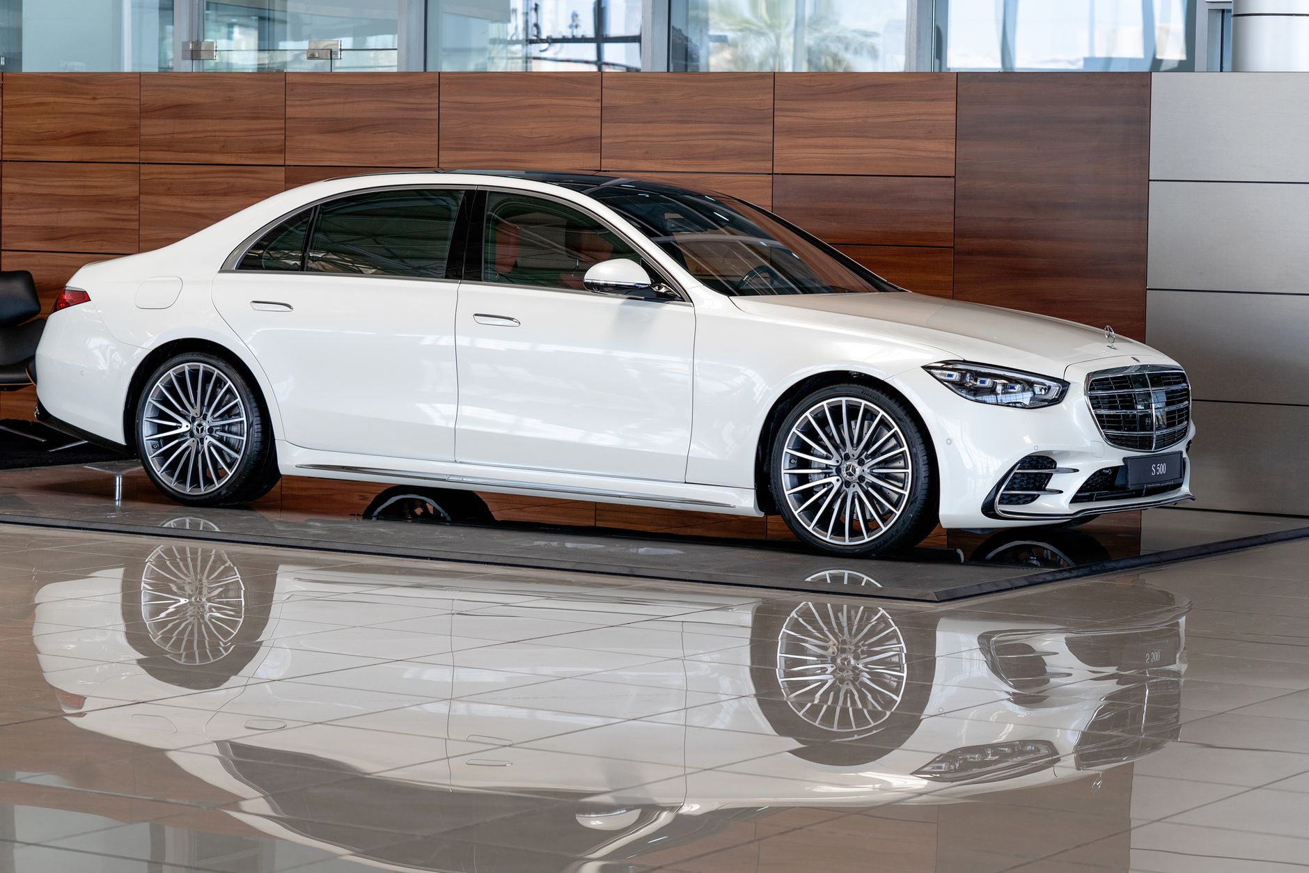 Sleek white Mercedes-Benz S-Class on display in a modern Dubai showroom.