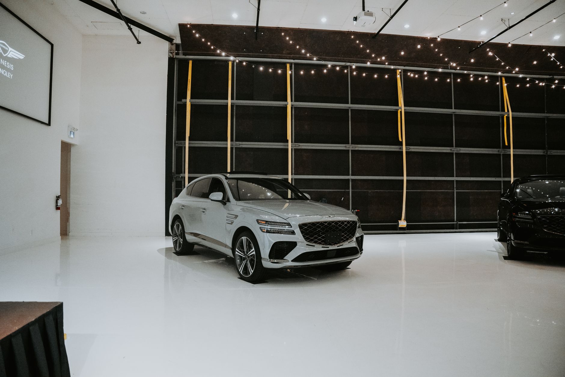 Sleek luxury cars displayed in a modern indoor showroom with elegant lighting.
