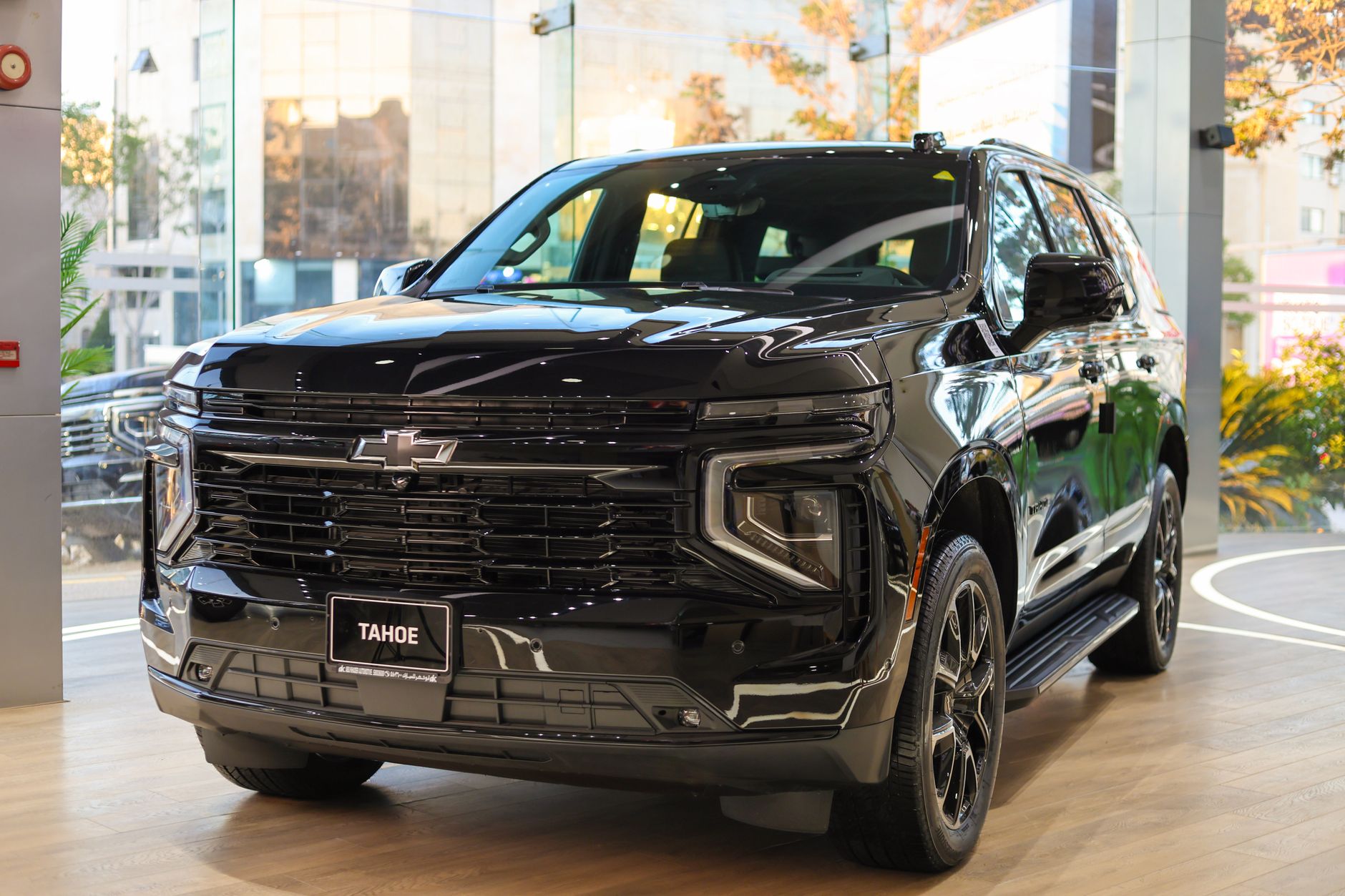 Black SUV showcased indoors with a modern design, highlighting luxury automotive styling.