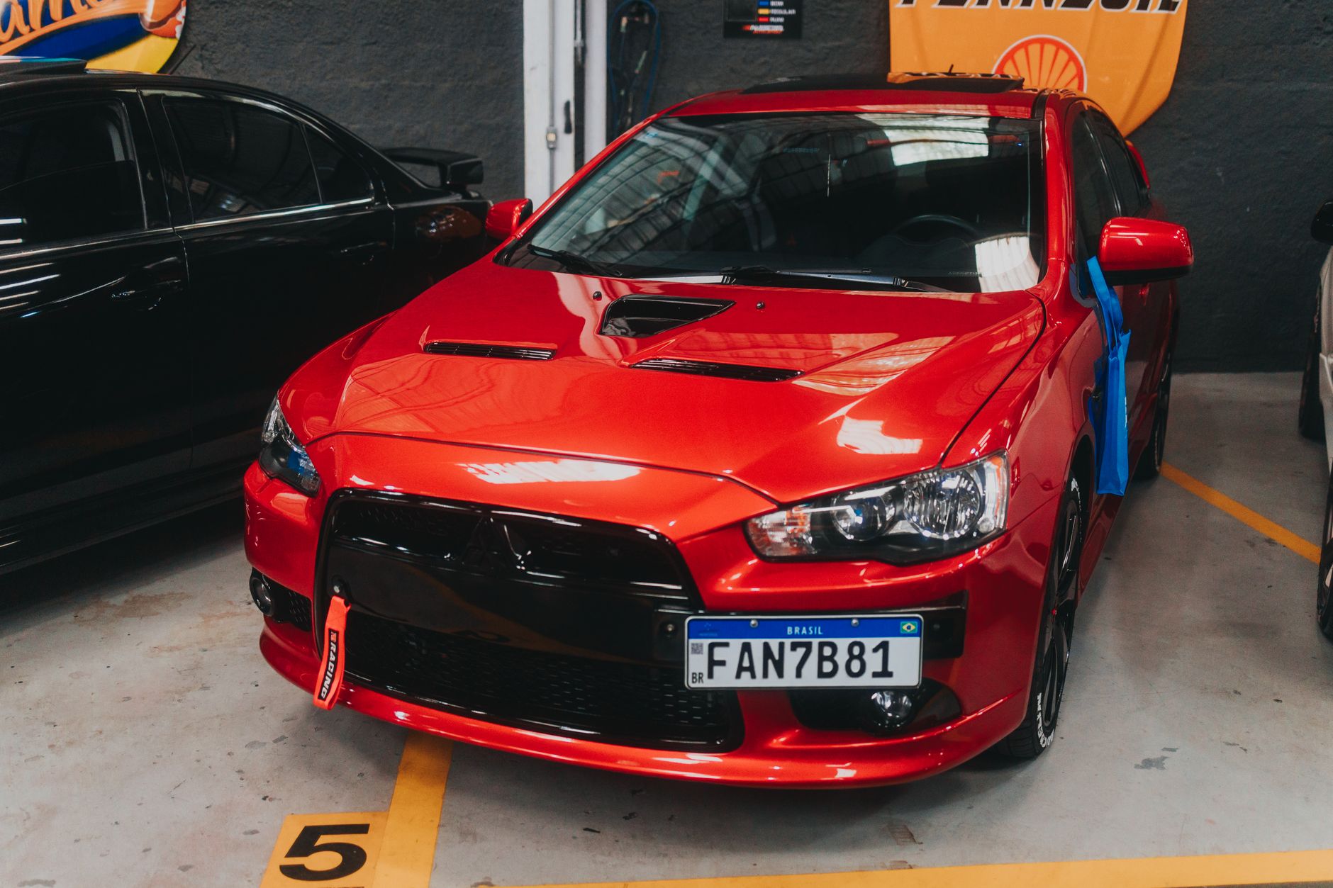 Vibrant red sports car parked indoors, showcasing sleek design.
