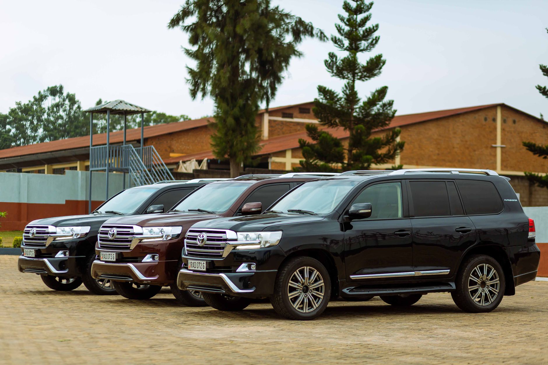 Three Toyota Land Cruiser SUVs parked outdoors on a sunny day.