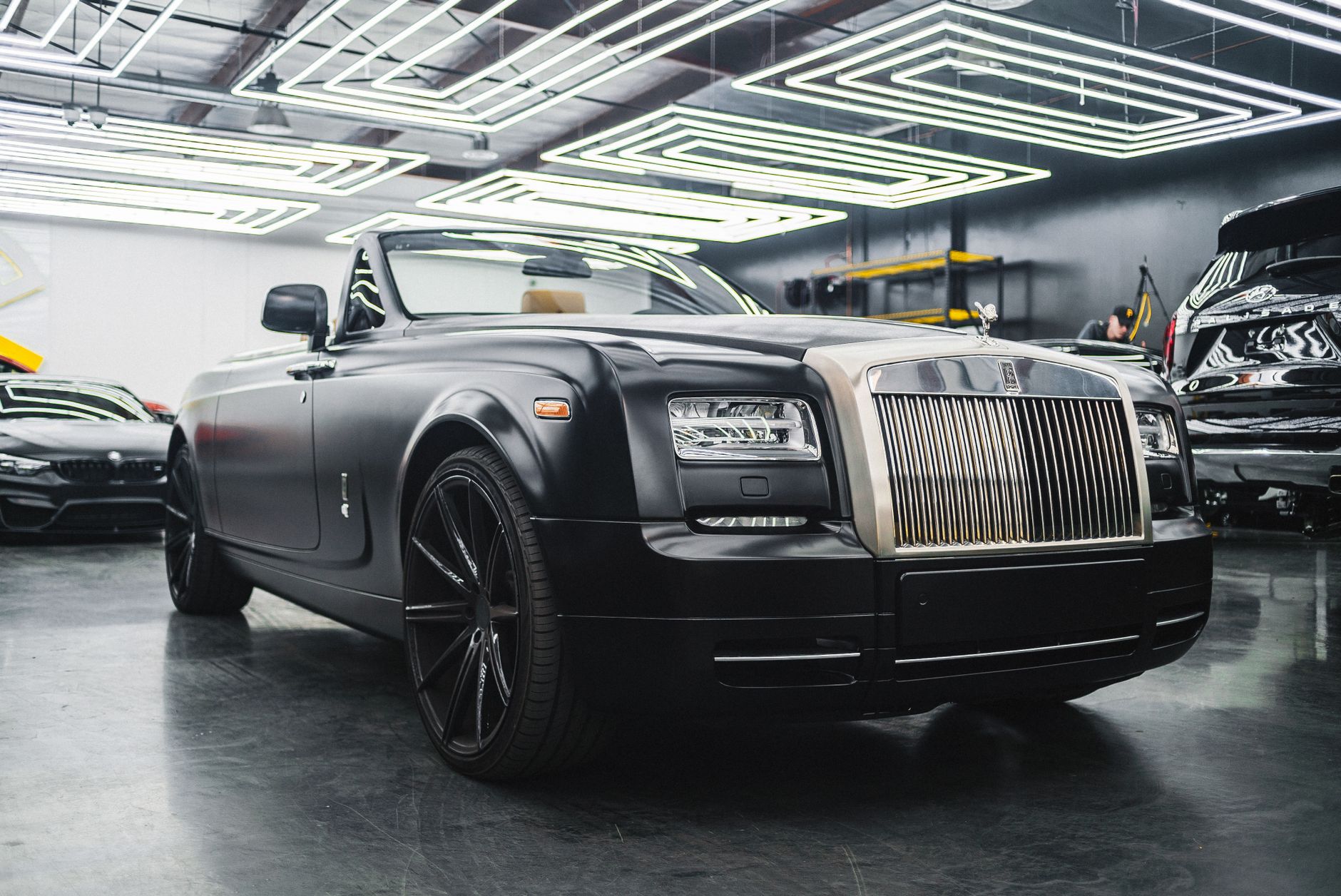 Elegant contemporary fashioned car of black color parked in garage under shiny modern lamps on ceiling