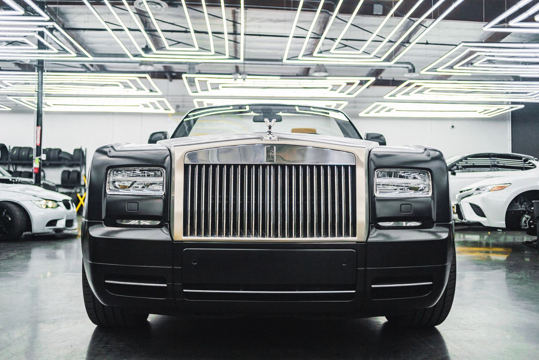 Front view of a sleek Rolls Royce in a modern showroom. Captivating luxury and elegance.