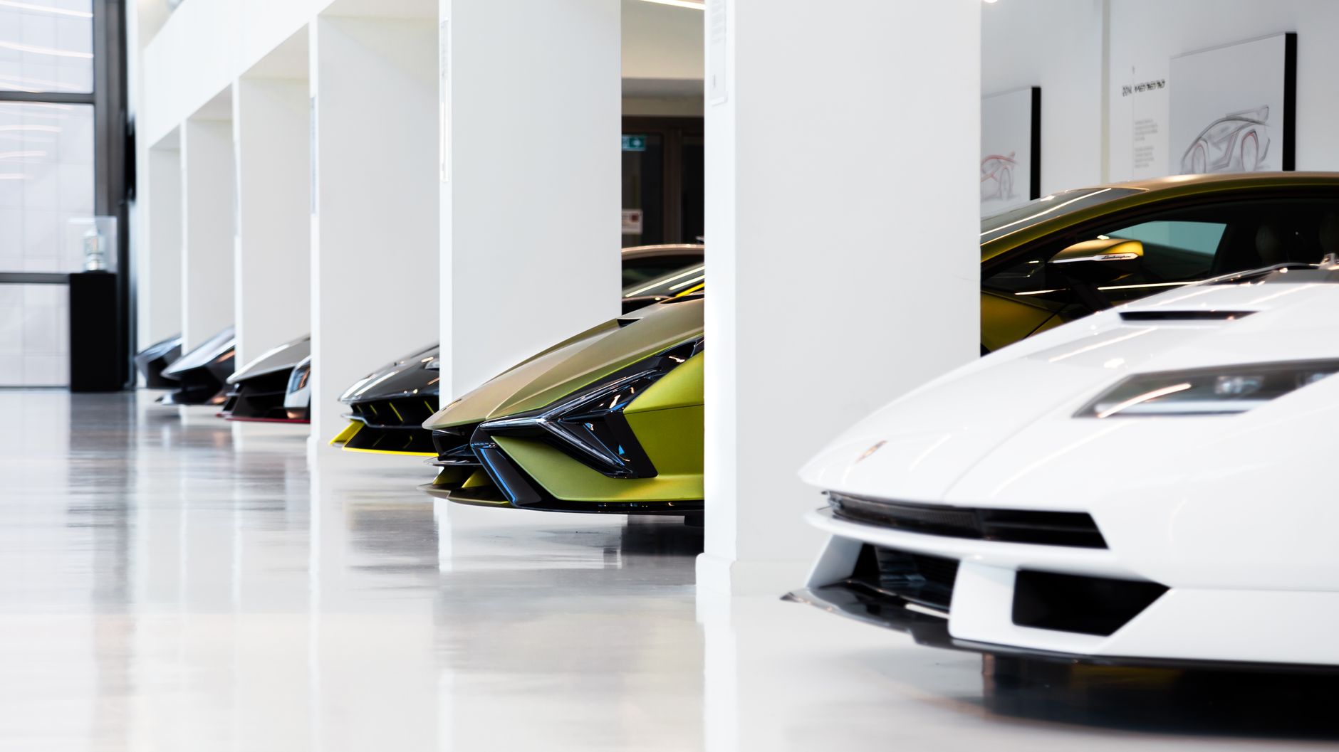 A lineup of luxury supercars in a well-lit, modern automotive museum scene.