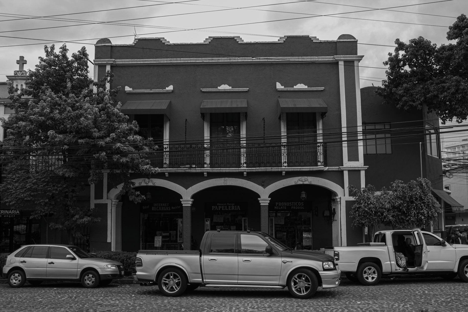 Black and white street view of historic architecture with parked cars in Ciudad de México.