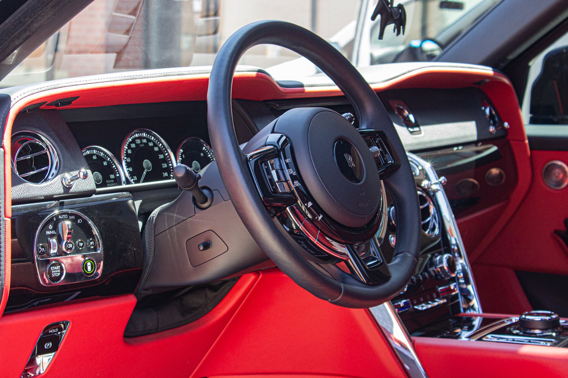 Close-up of a luxury car interior showcasing red leather trim and dashboard details.
