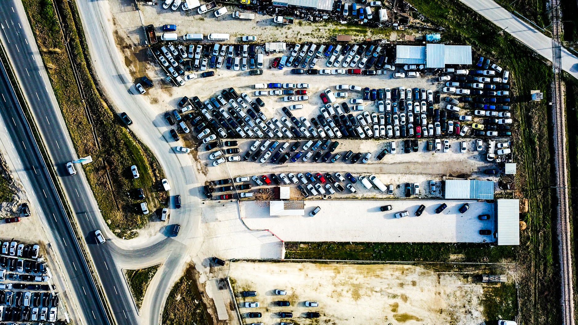 Drone image showcasing a parking lot and roads in an urban setting.