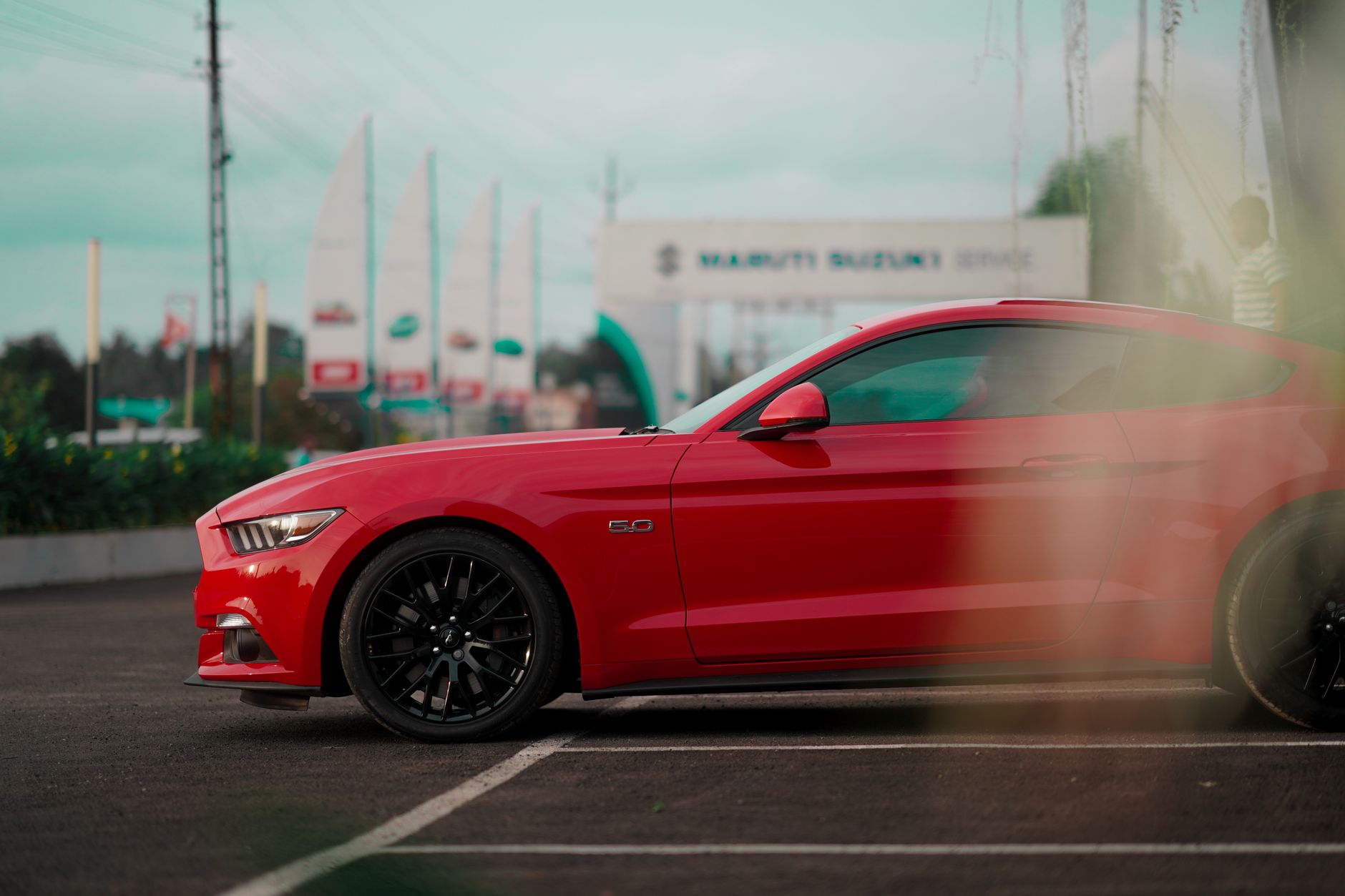 Sleek red Ford Mustang GT parked in an urban outdoor setting.