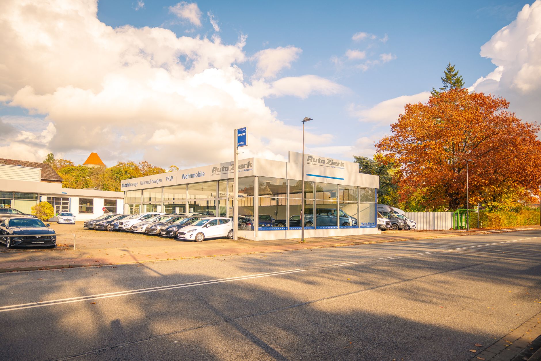 Charming auto dealership in Baine, Germany, accented by vibrant autumn foliage.