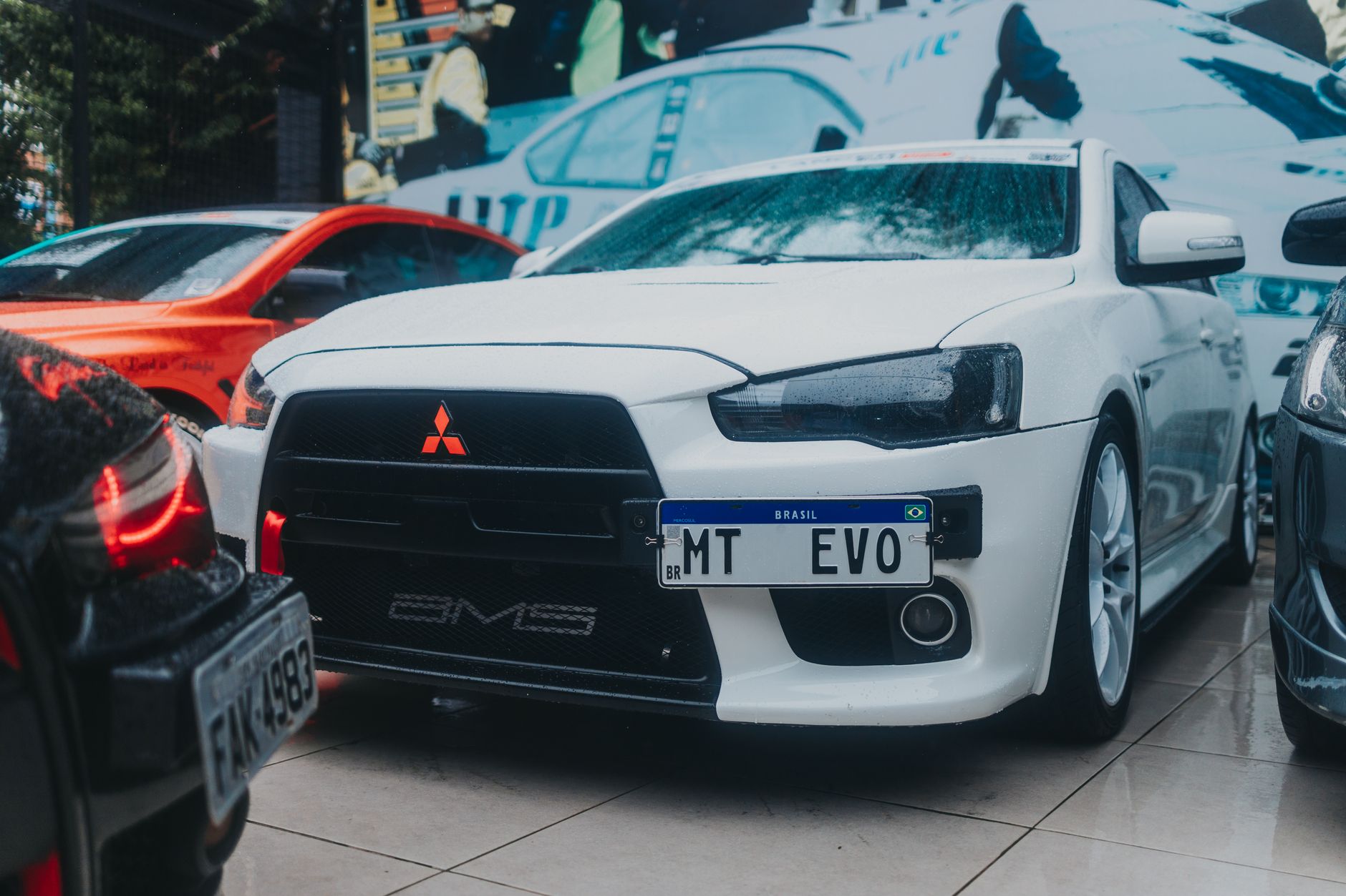 Close-up of a white Mitsubishi Lancer Evo parked outdoors with a Brazilian license plate.