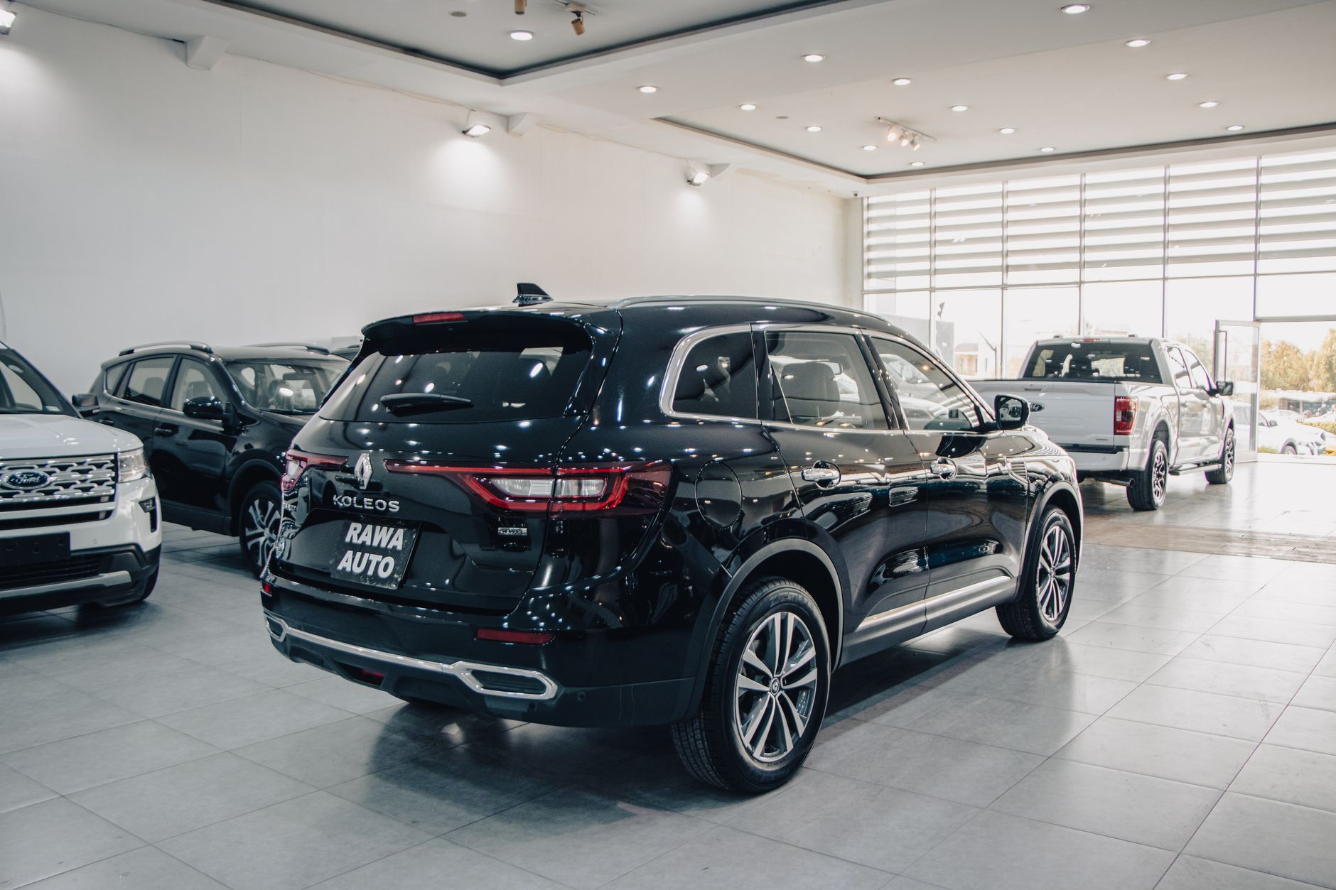 Spacious modern showroom featuring luxury cars on display.