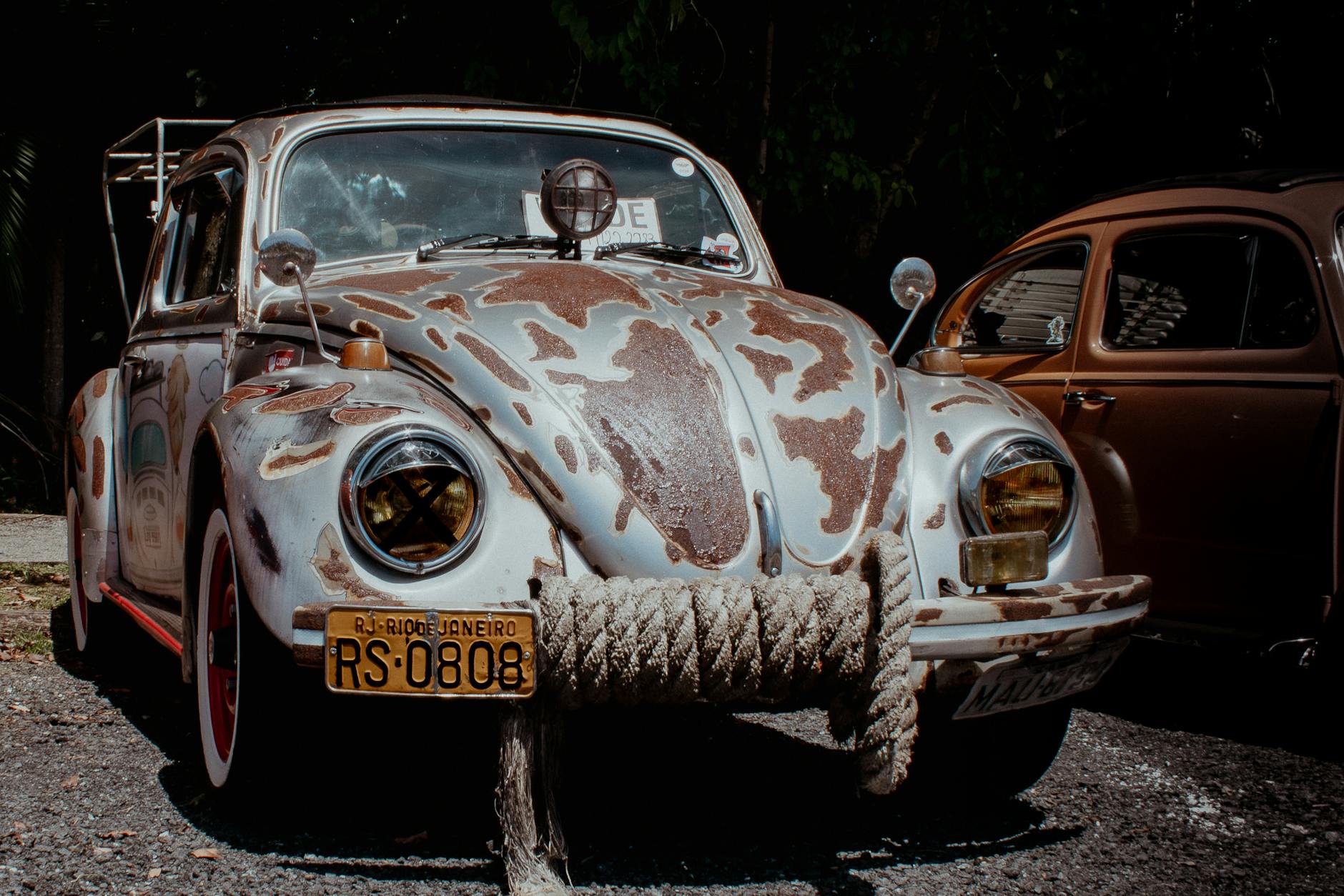 Rustic vintage Volkswagen with Rio de Janeiro plates parked outdoors.
