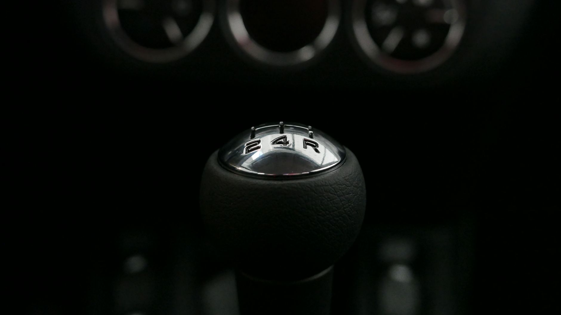 Detailed view of a manual shift knob in a vehicle, highlighting the gears.