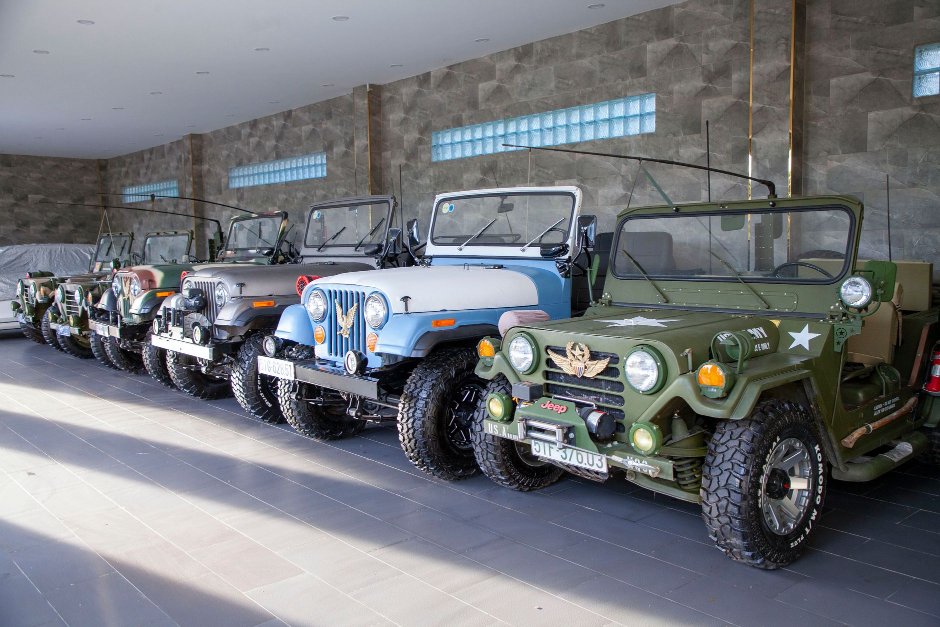Display of retro offroad vehicles in an indoor showroom with natural lighting.