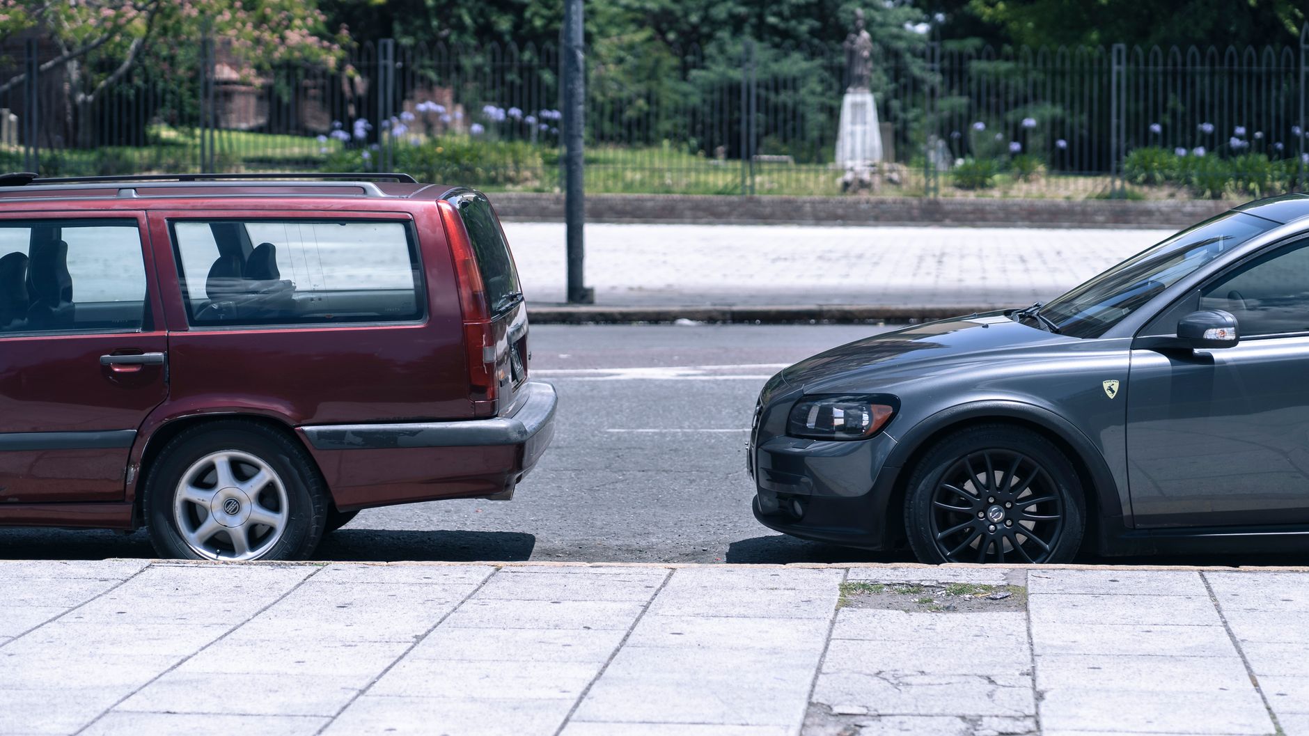 Two parked cars on a sunny street in La Plata, Argentina, showcasing a classic urban cityscape view.