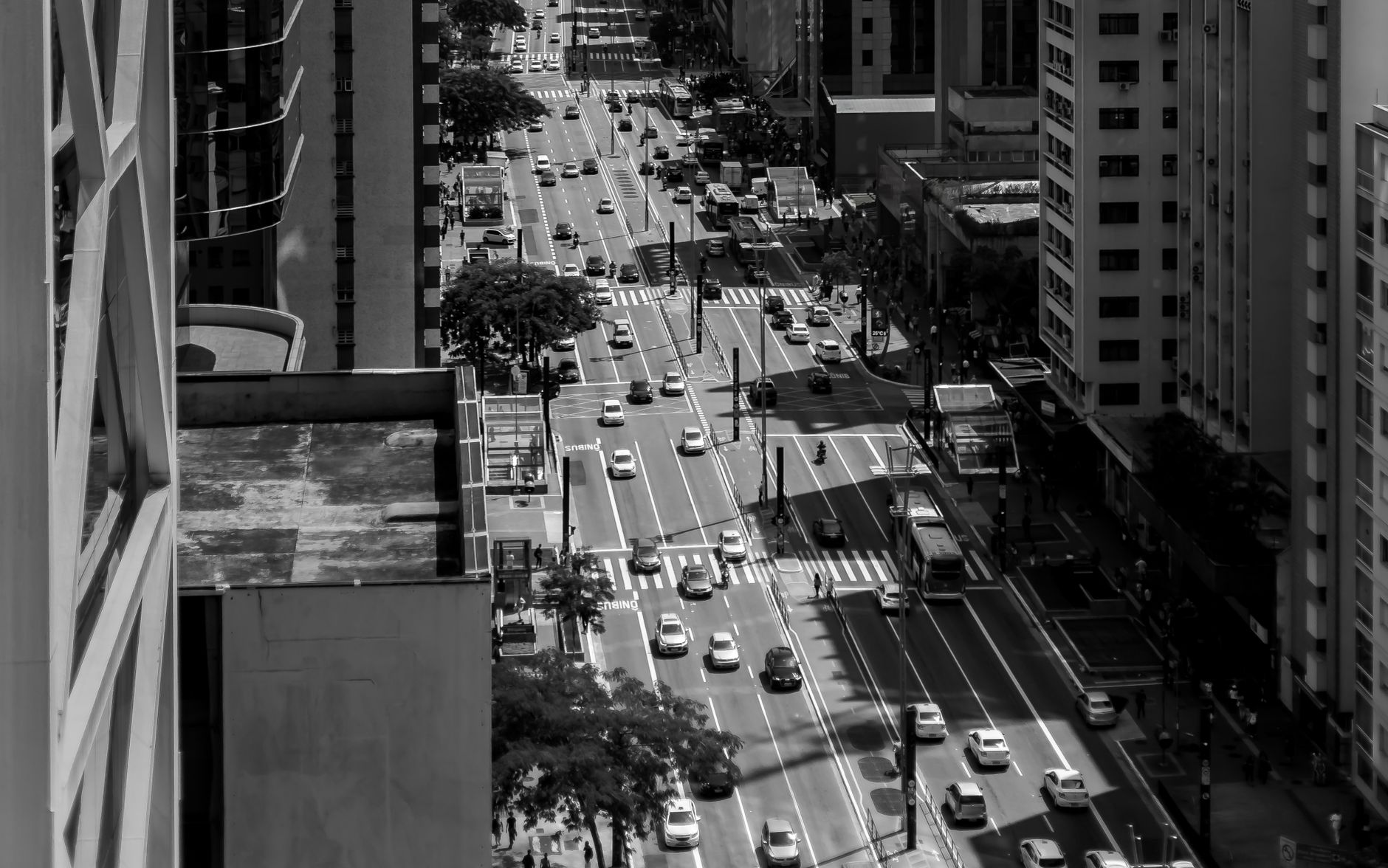 Aerial view of a busy street in São Paulo, capturing urban life in black and white.
