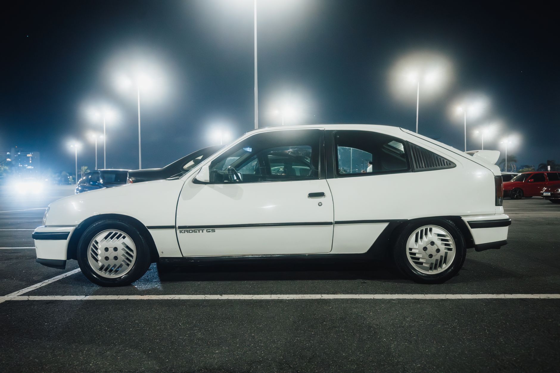 Classic Opel Kadett GSi 1987 in parking lot under bright streetlights.
