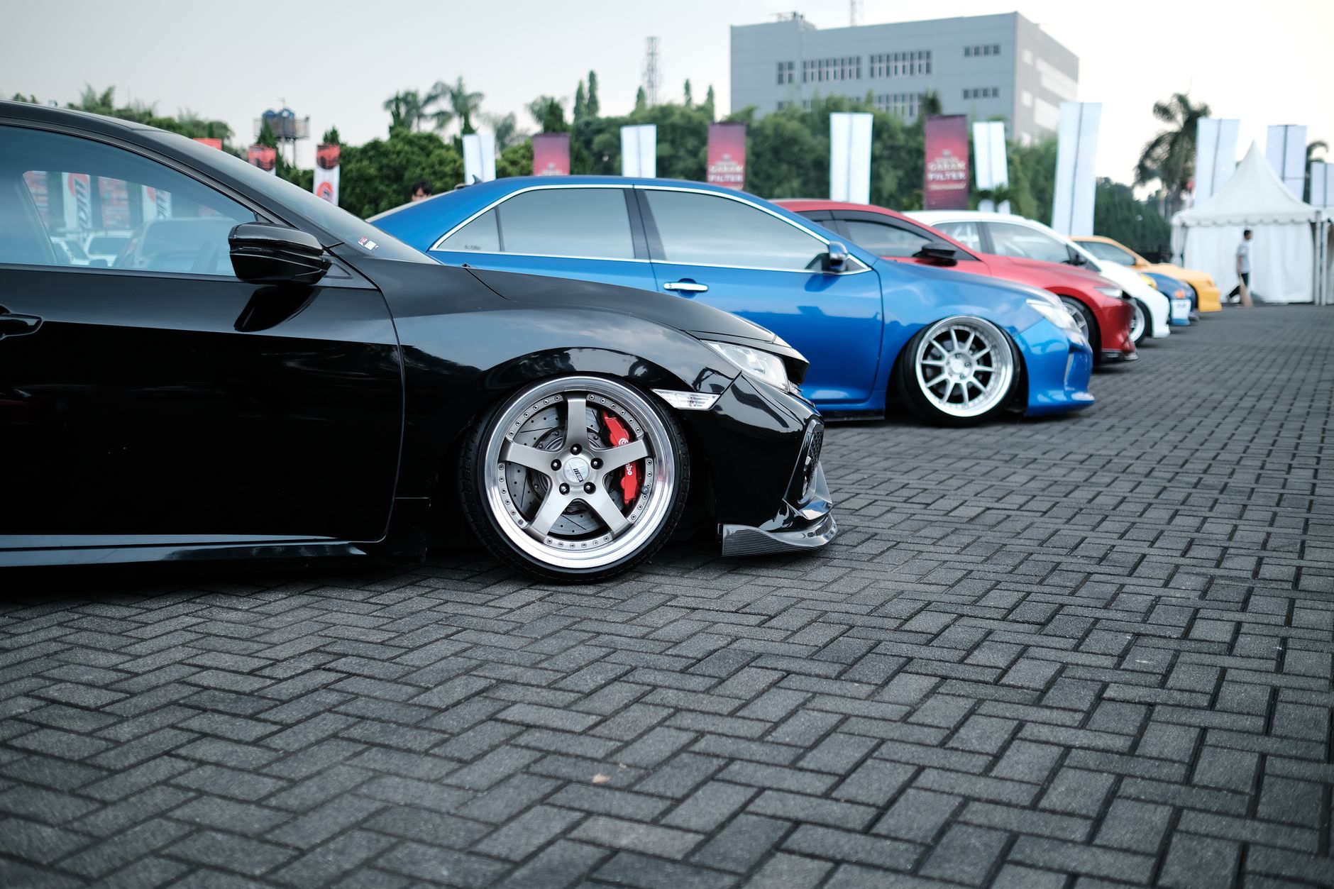 Showcase of sleek customized sports cars parked in an outdoor exhibition.