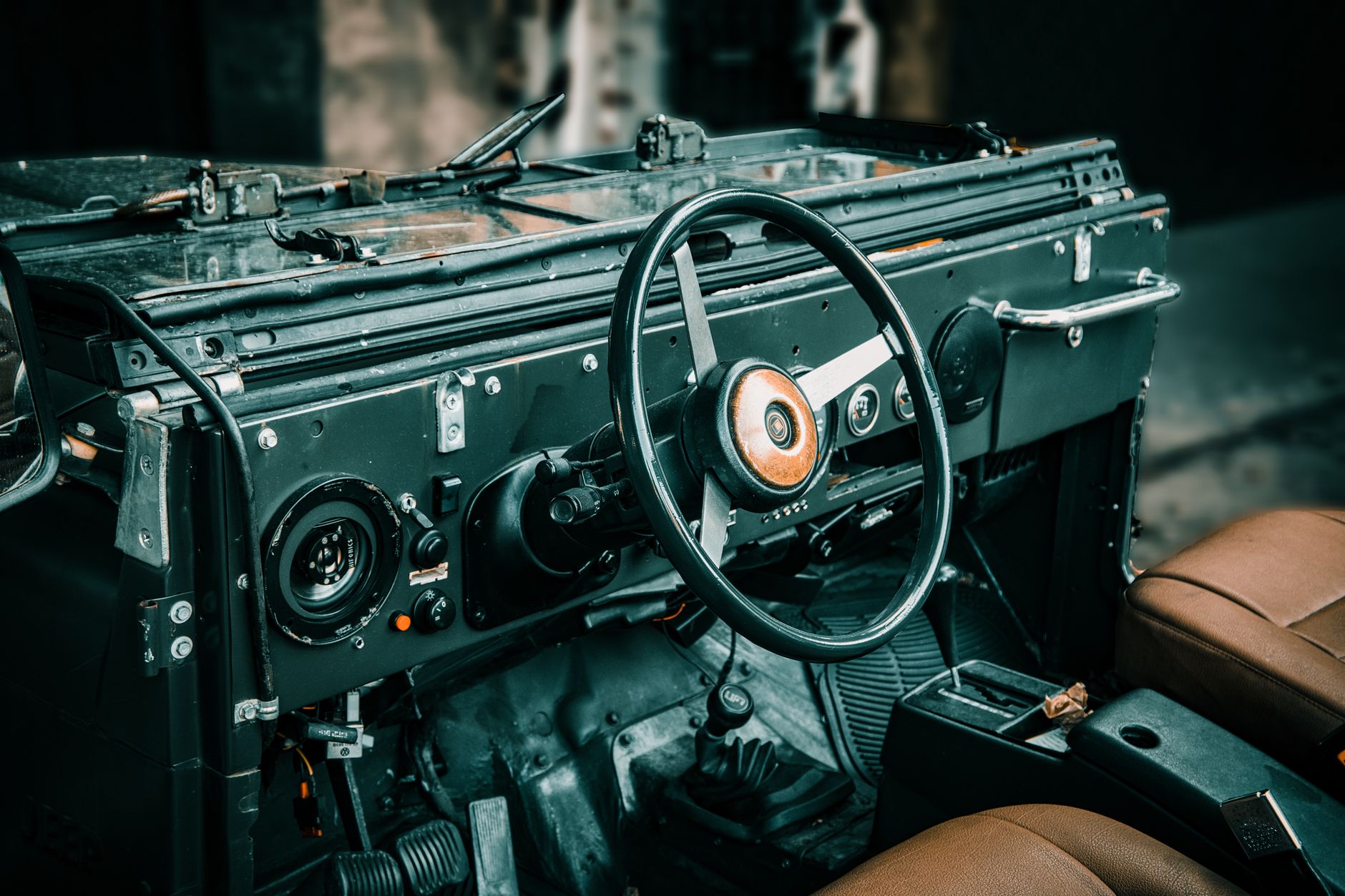 Experience nostalgia with this vintage jeep interior showcasing a classic steering wheel and dashboard.