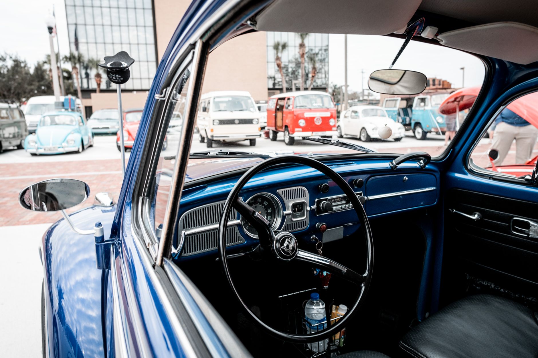 Close-up of a vintage Volkswagen interior with classic cars outside.