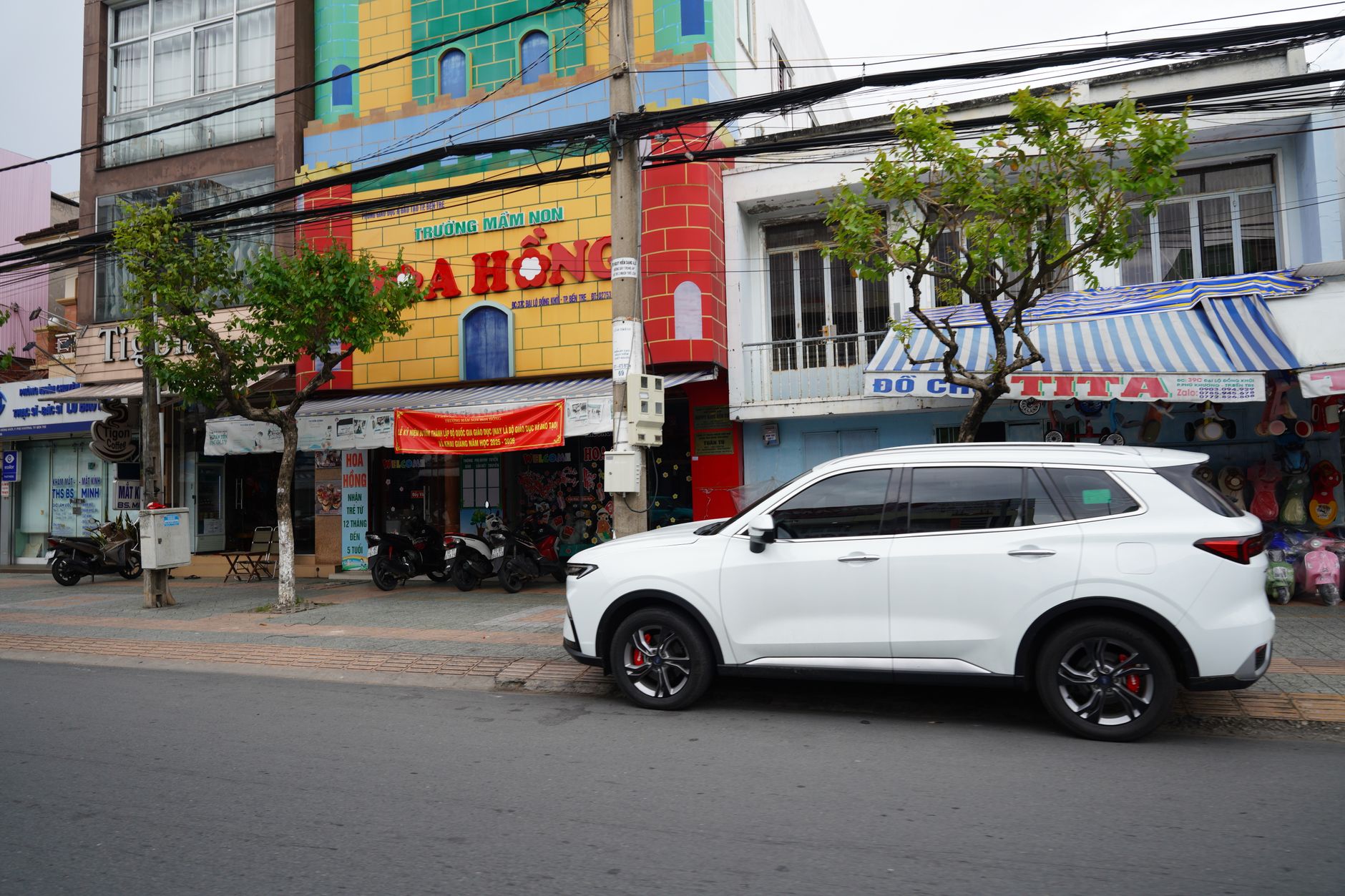 A vibrant urban street scene featuring a white SUV parked beside colorful buildings with vivid facades.
