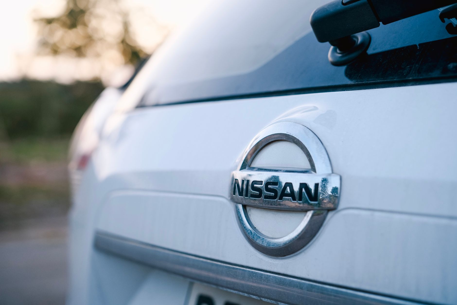 A close-up image of the logo on a Nissan car's trunk, highlighting the brand emblem in a sleek design.