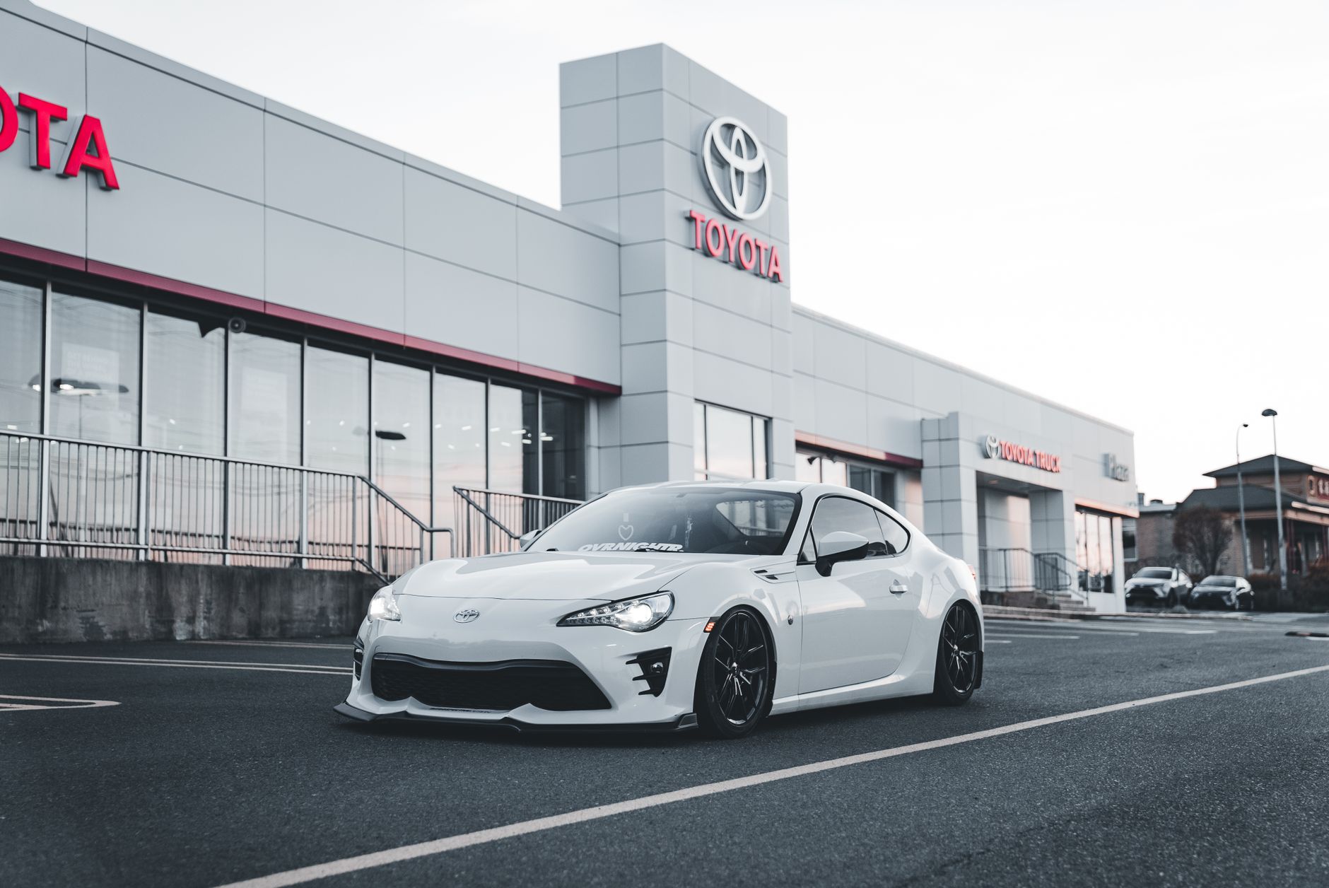 White Toyota sports car parked at a dealership, showcasing style and performance.