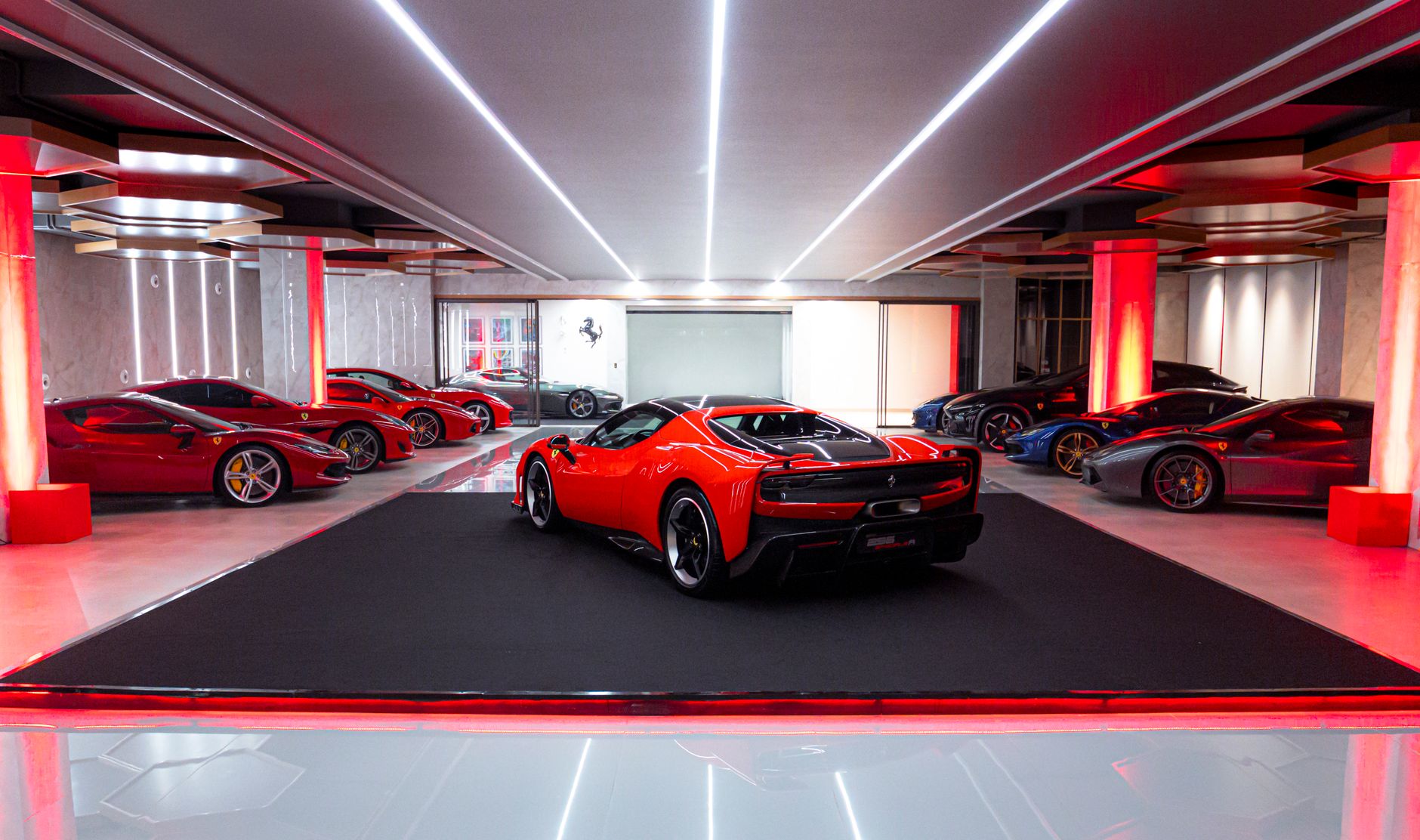 Collection of sleek luxury sports cars in a stylishly lit indoor showroom.