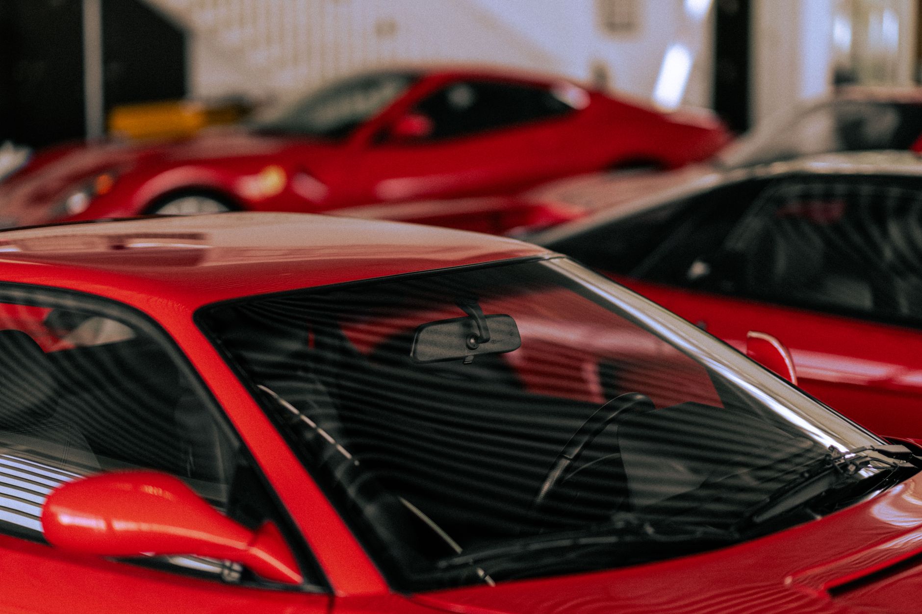 Detailed view of red sports cars parked inside a garage, showcasing their sleek design and vibrant color.
