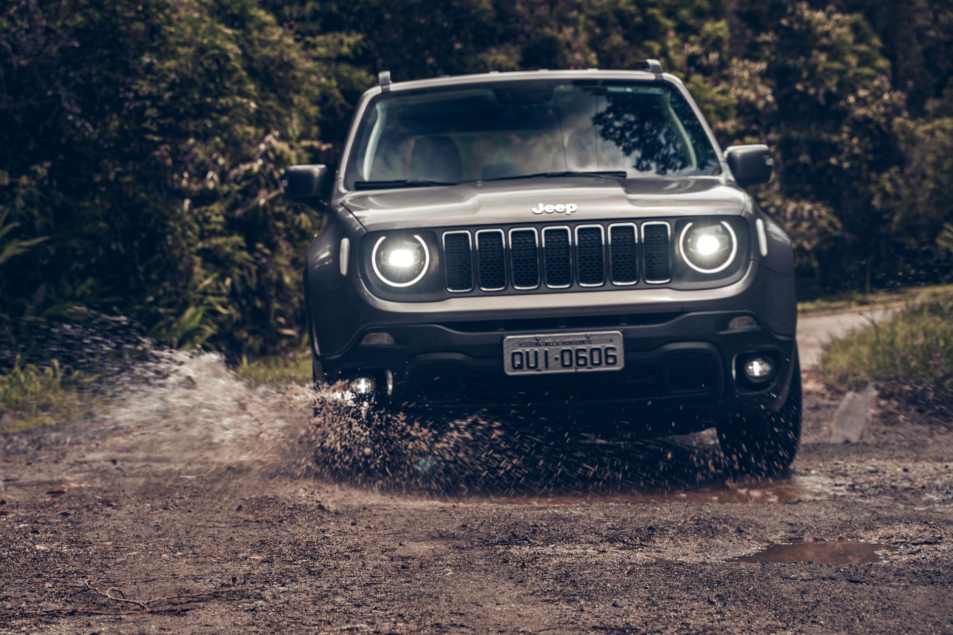 A rugged Jeep navigating a muddy off-road trail amidst lush greenery in São Paulo.