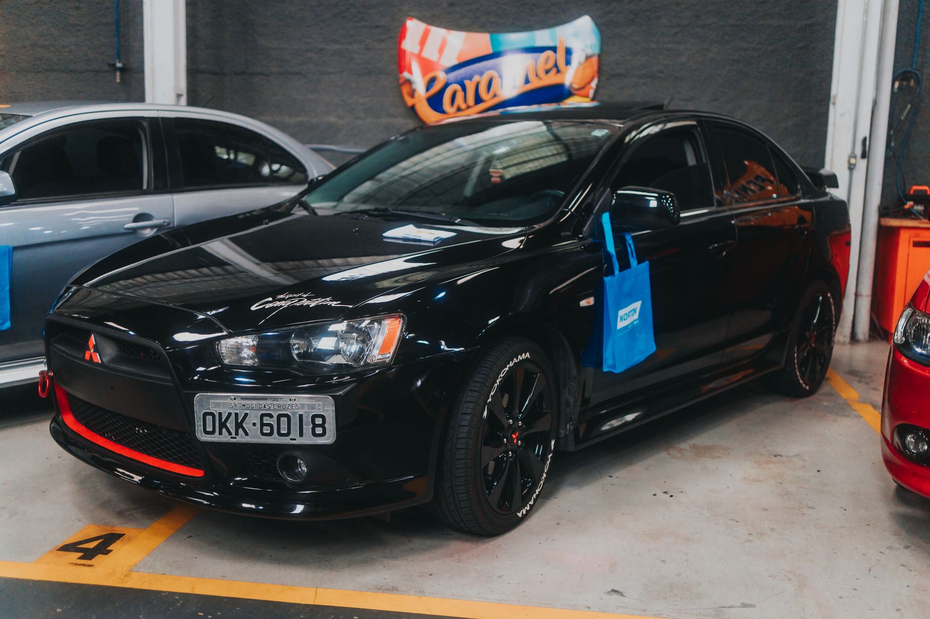 Black Mitsubishi Lancer parked in an indoor garage. Ideal for car enthusiasts and automotive collections.
