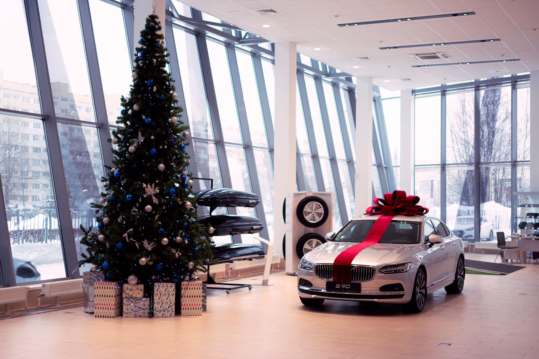 Elegant car with festive decorations inside a modern showroom.