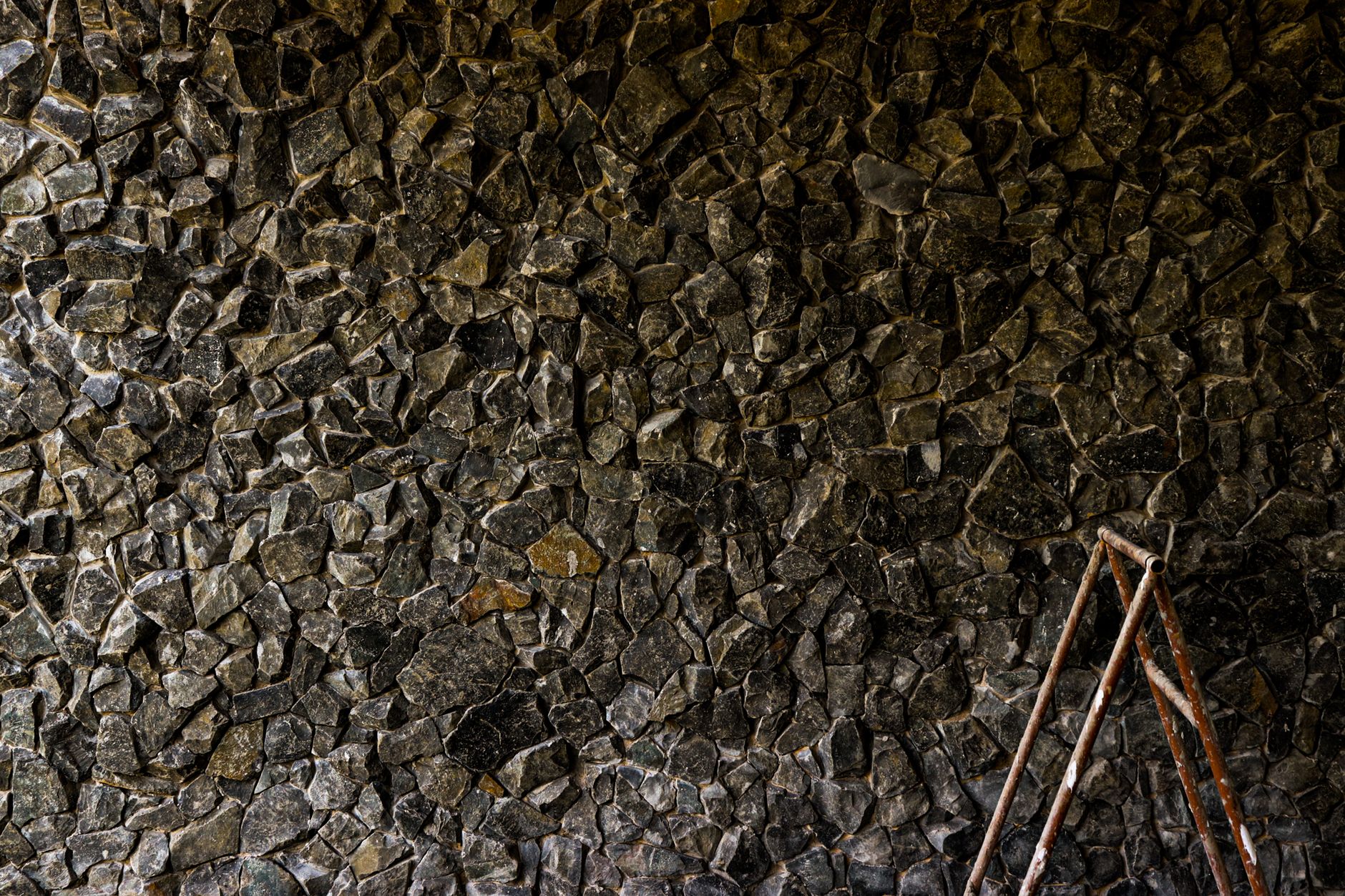 Textured stone wall with rustic ladder in São José do Rio Preto, Brazil.