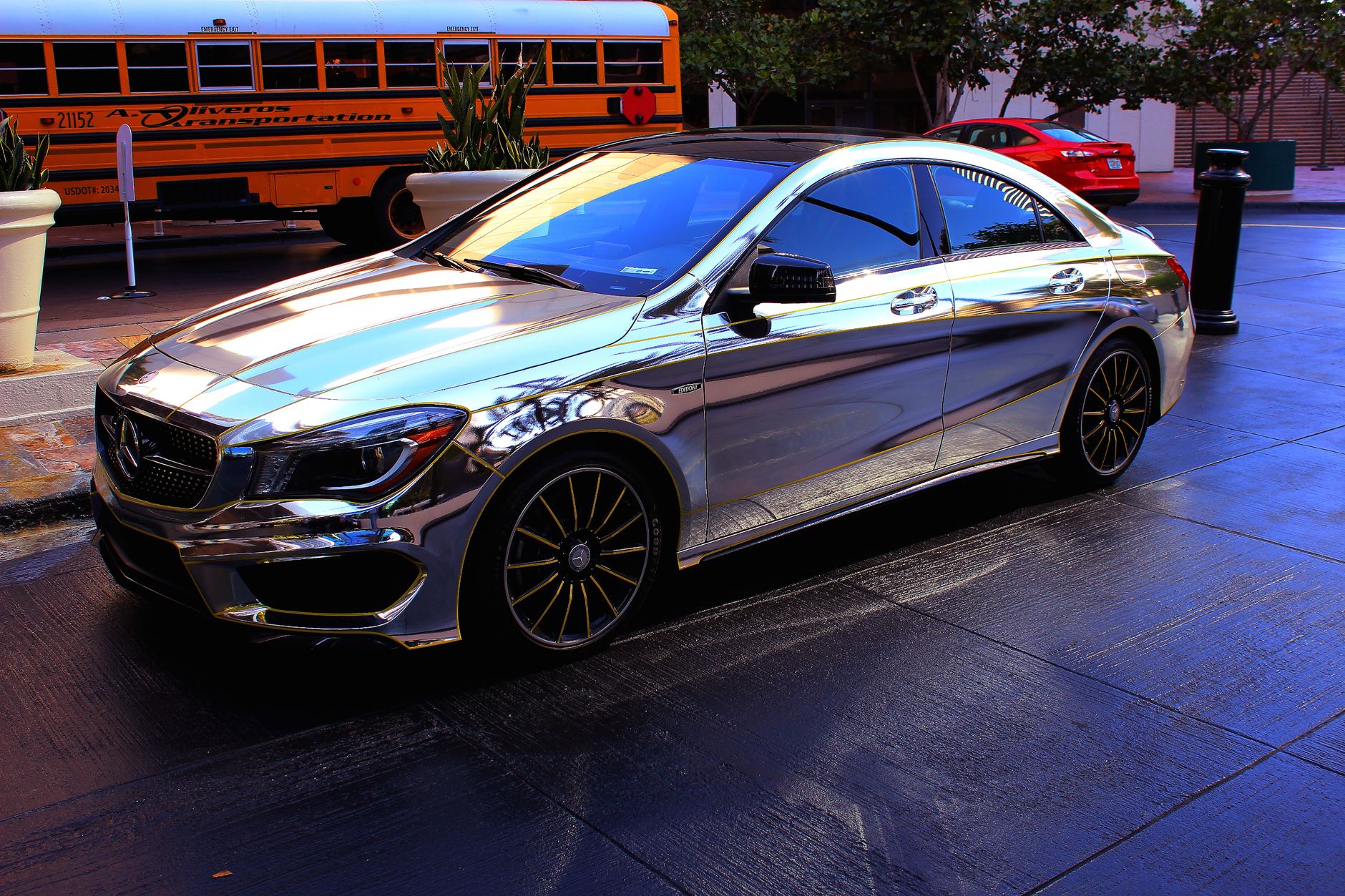 Luxurious chrome Mercedes parked on a city street, capturing reflections and urban surroundings.