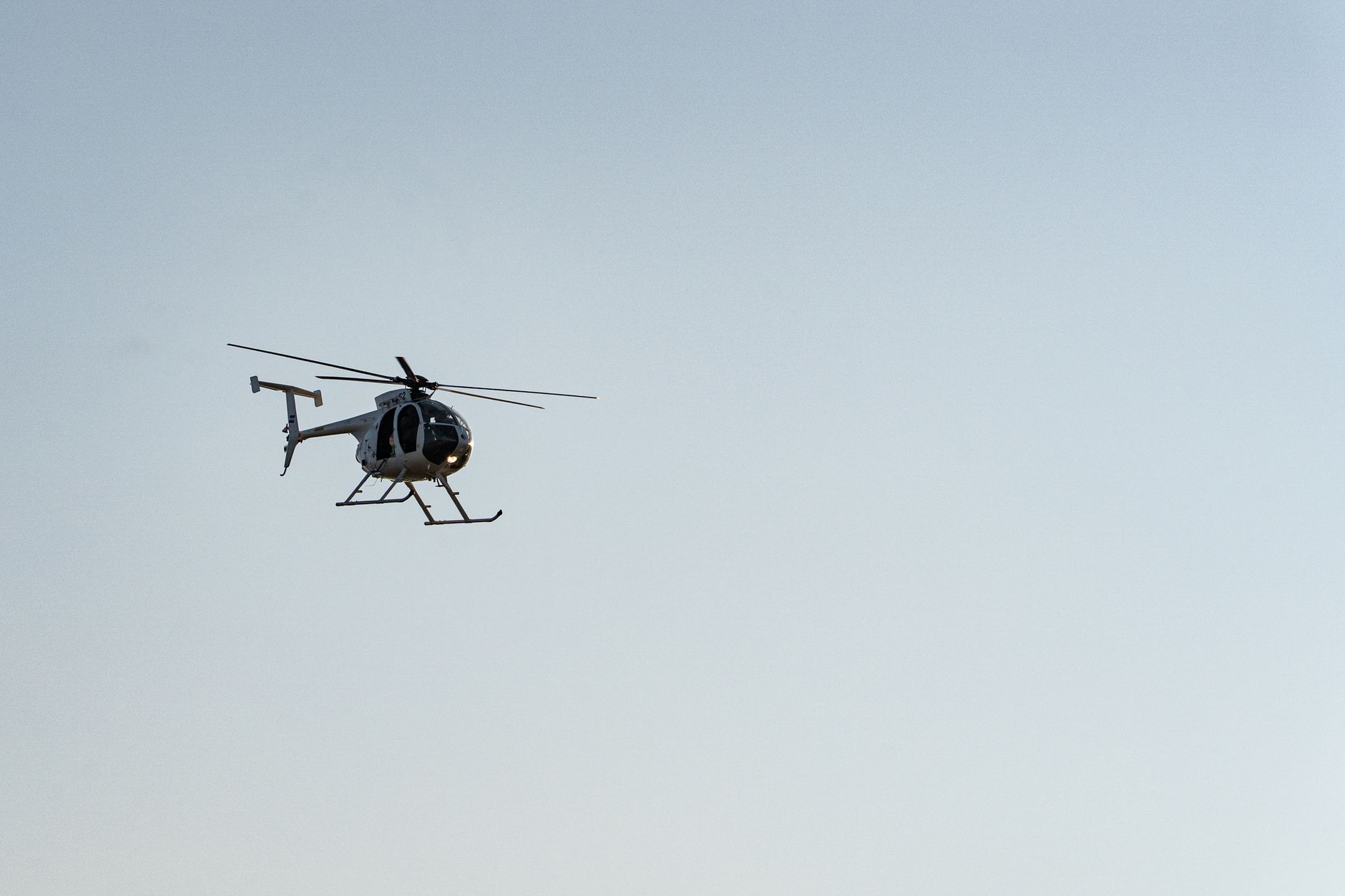 A helicopter flying in the clear blue sky above El Salvador, showcasing aviation in a serene setting.