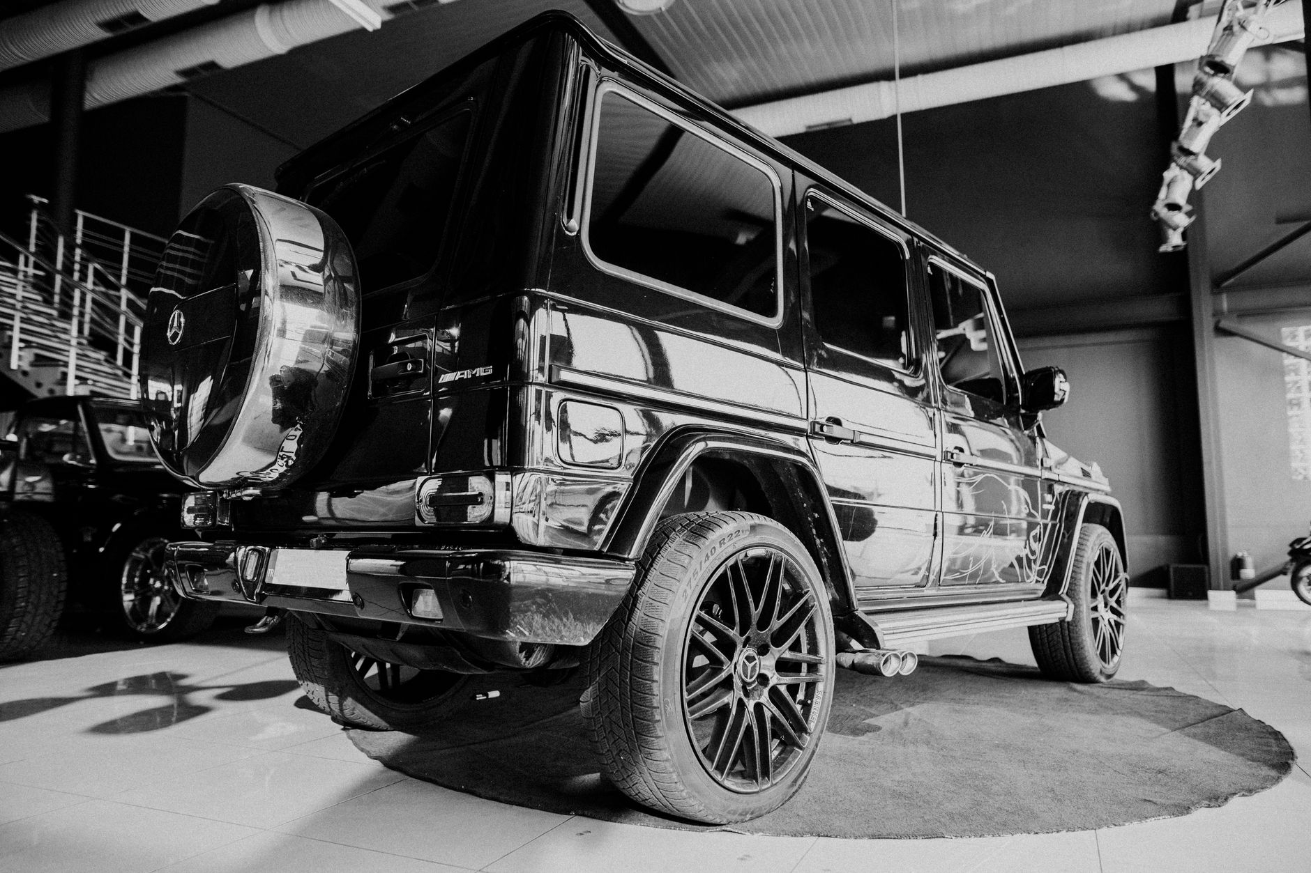 Black and white photo of a classic Mercedes Benz luxury car in a showroom.
