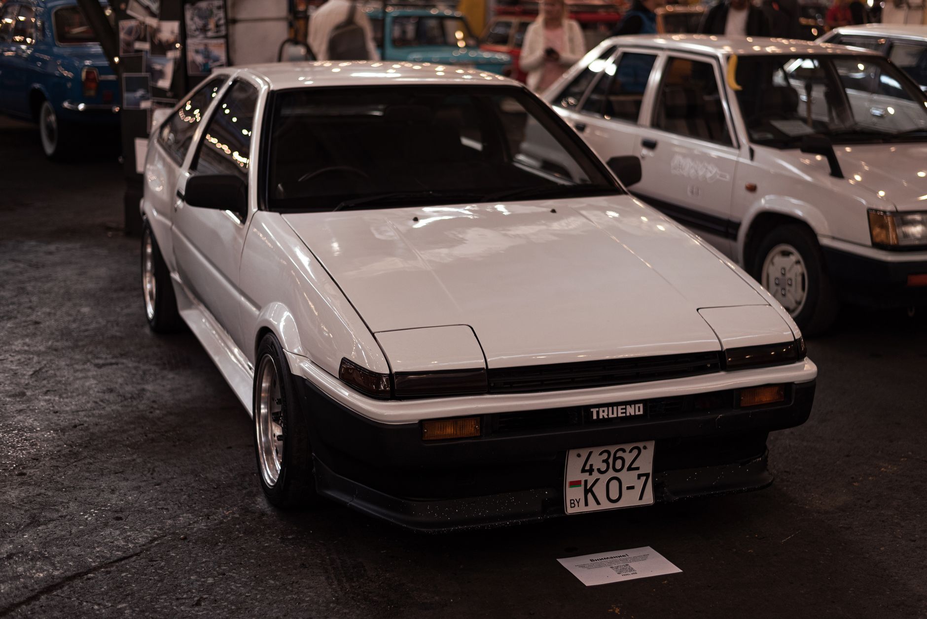 White Toyota Trueno showcased at an indoor car exhibition, highlighting a classic vintage design.
