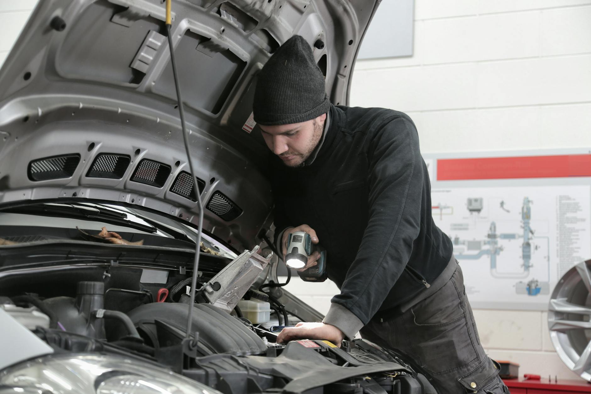 Mecânico inspecionando motor de Fiat Strada revisada