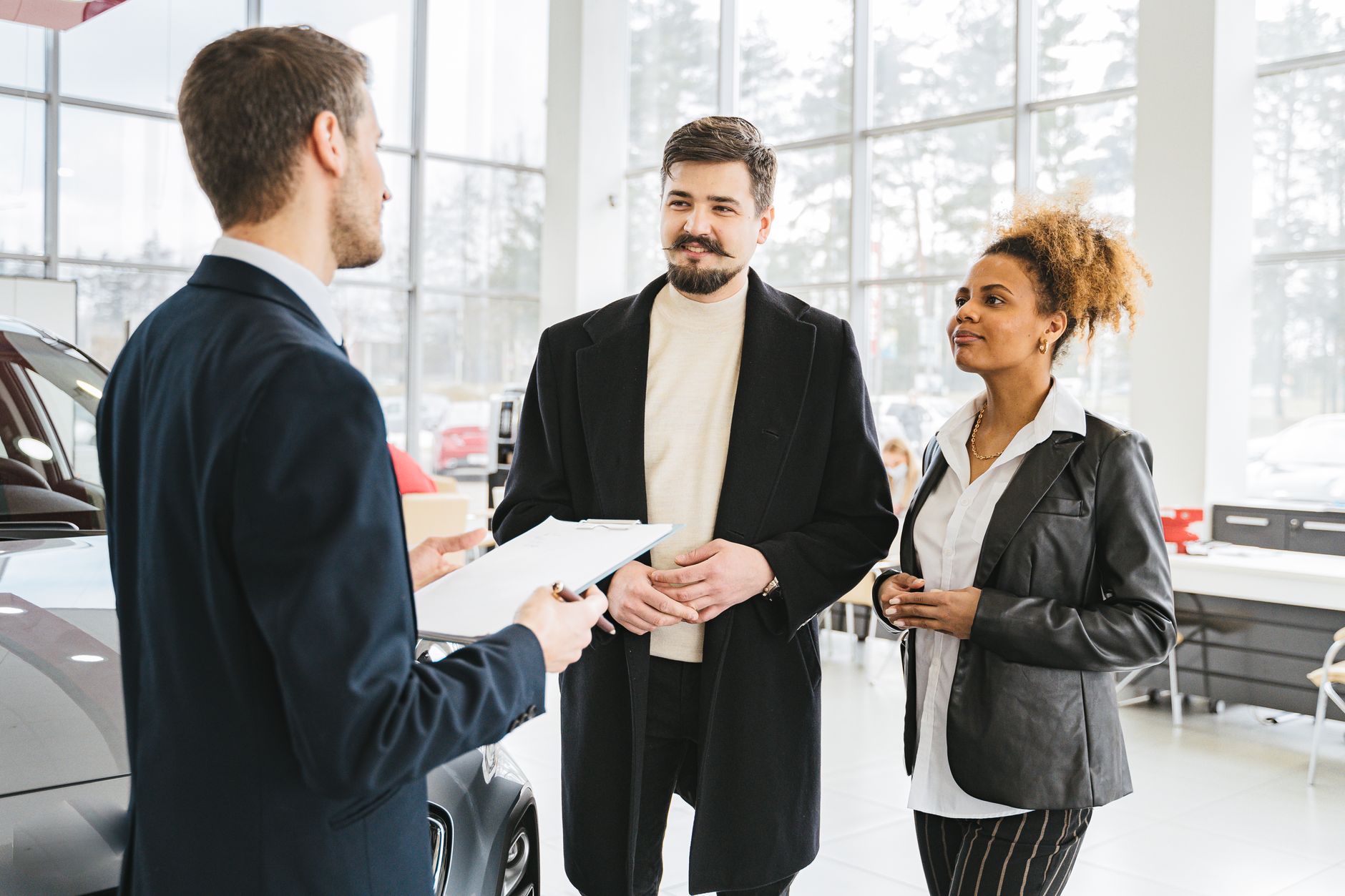 Cliente satisfeito apertando a mão de vendedor em concessionária